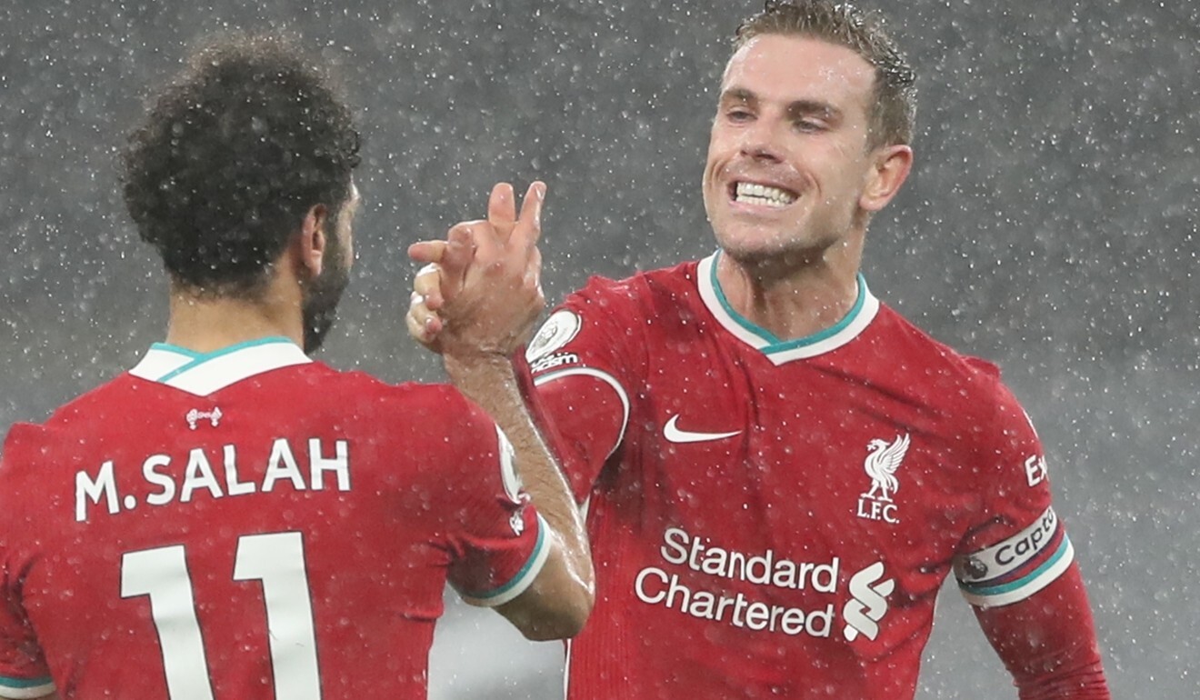 Liverpool star Mohamed Salah celebrates with captain Jordan Henderson after their Premier League match against Tottenham Hotspur in London in January. Photo: EPA