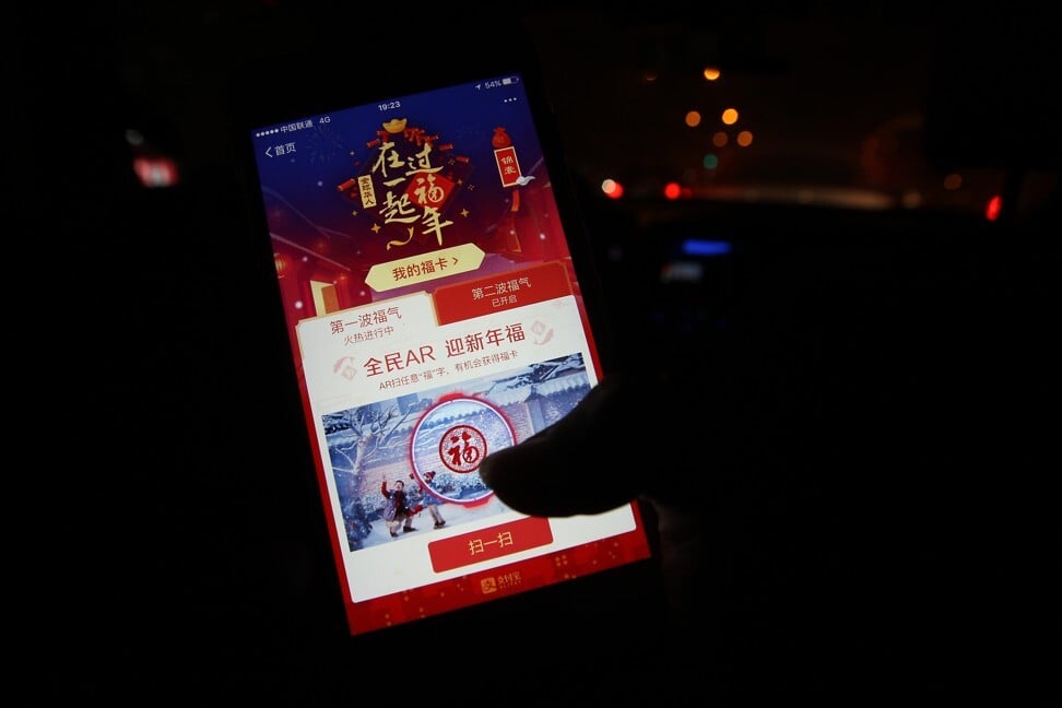 A man taps his smartphone to grab a Lunar New Year digital red packet, while riding inside a taxi in Beijing on January 28, 2017. Photo: SCMP