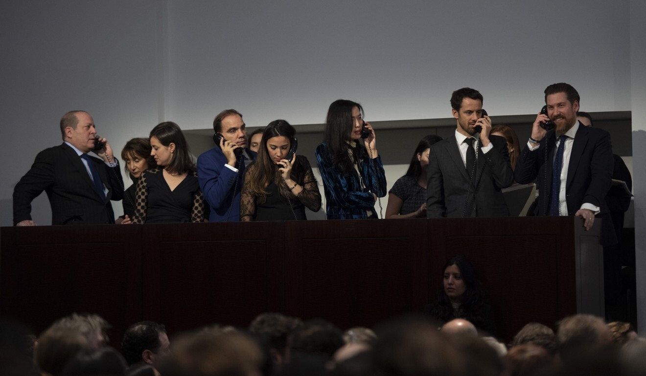 Agents take competing bids from their clients on the phone at a Christie’s auction in New York on November 15, 2018. Photo: AFP