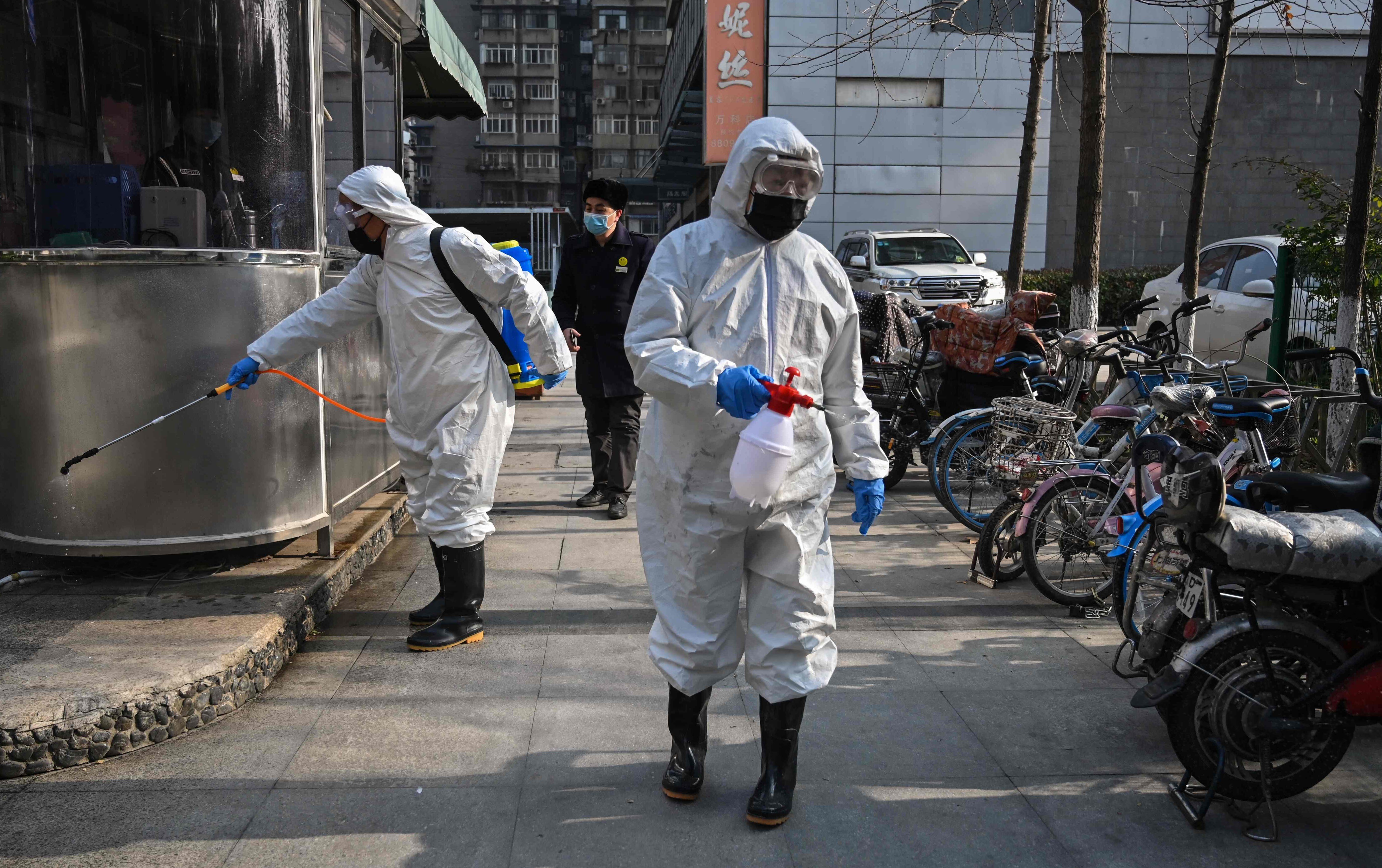 People dressed in protective clothes disinfect an area in Wuhan, in China’s Hubei province, on January 29, 2020. A WHO team recently visited the city, where the first Covid-19 cases were detected, as part of a probe into the origins of Covid-19. Photo: AFP
