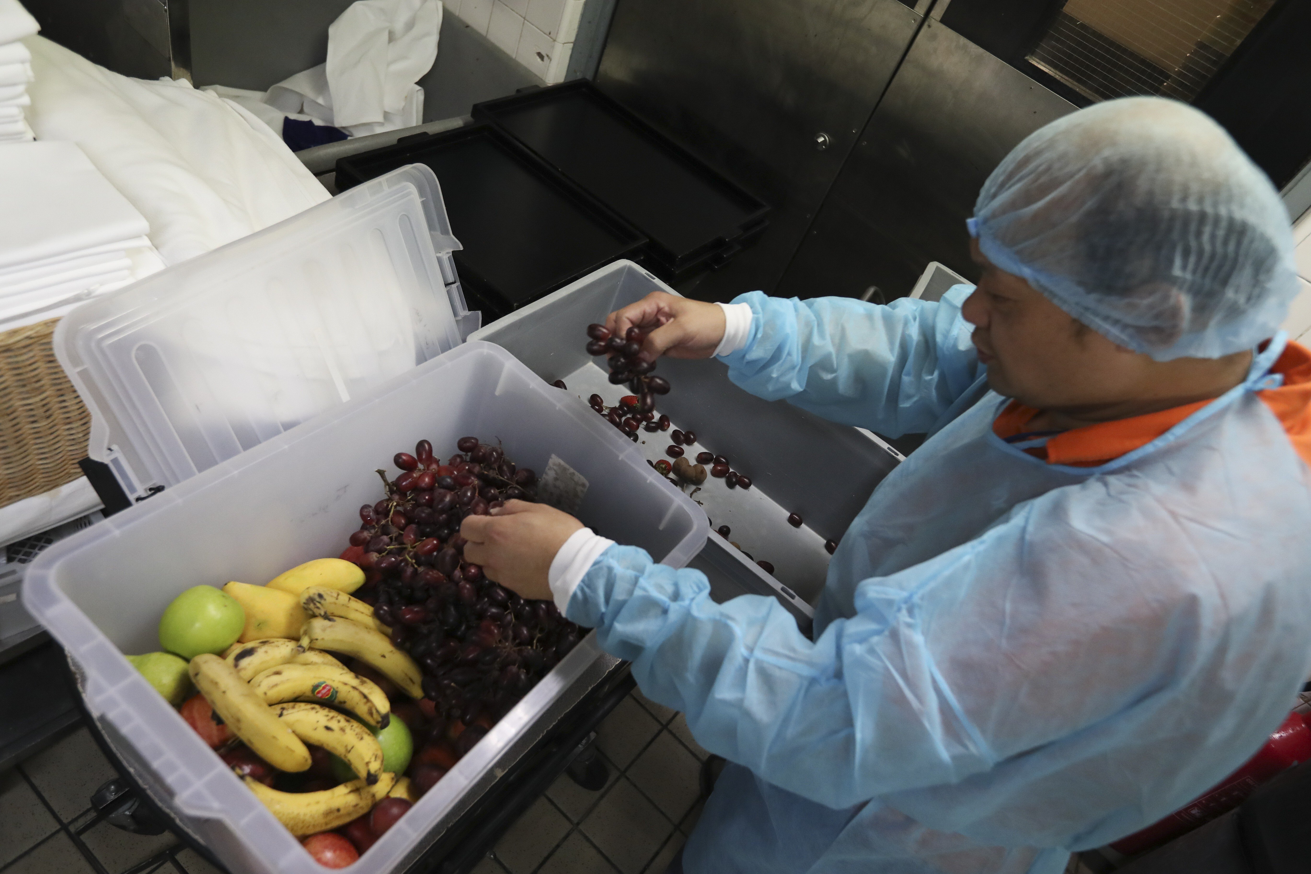 A worker at the Grand Hyatt Hotel packs up excess food to give to a charity. Photo: Nora Tam