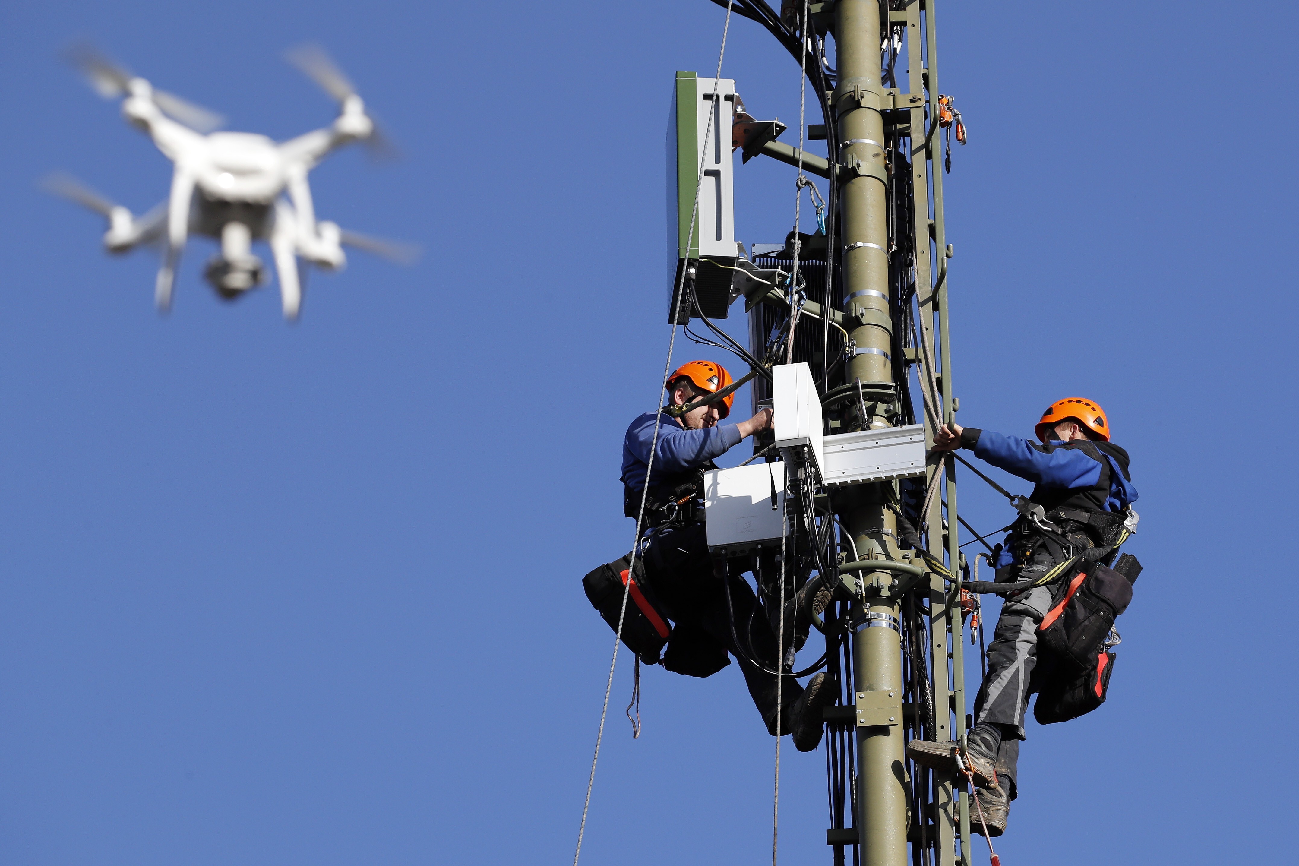 A drone flies alongside engineers as they equip a Swisscom network mast with Ericsson’s 5G base stations in Hindelbank, Switzerland, on December 18, 2019. Photo: Bloomberg