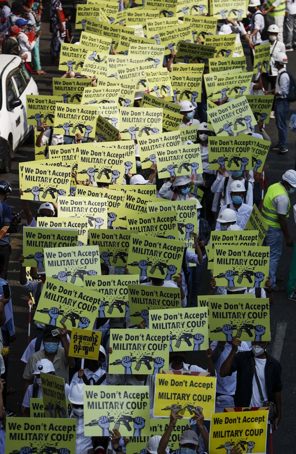 Demonstrators in Yangon hold placards during a protest against the military coup. Photo: EPA