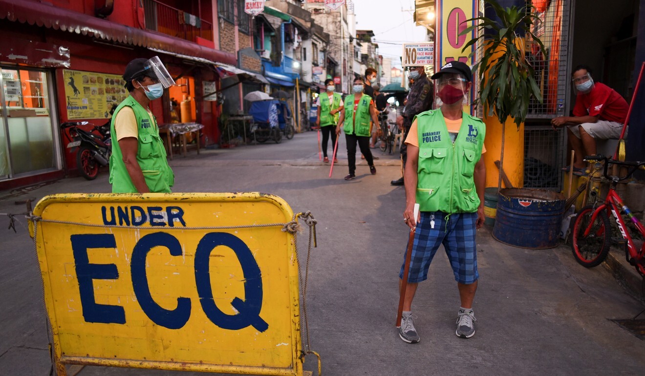 Local officials stand guard at an “Extreme Community Quarantine” checkpoint in Pasay, Metro Manila. Photo: Reuters