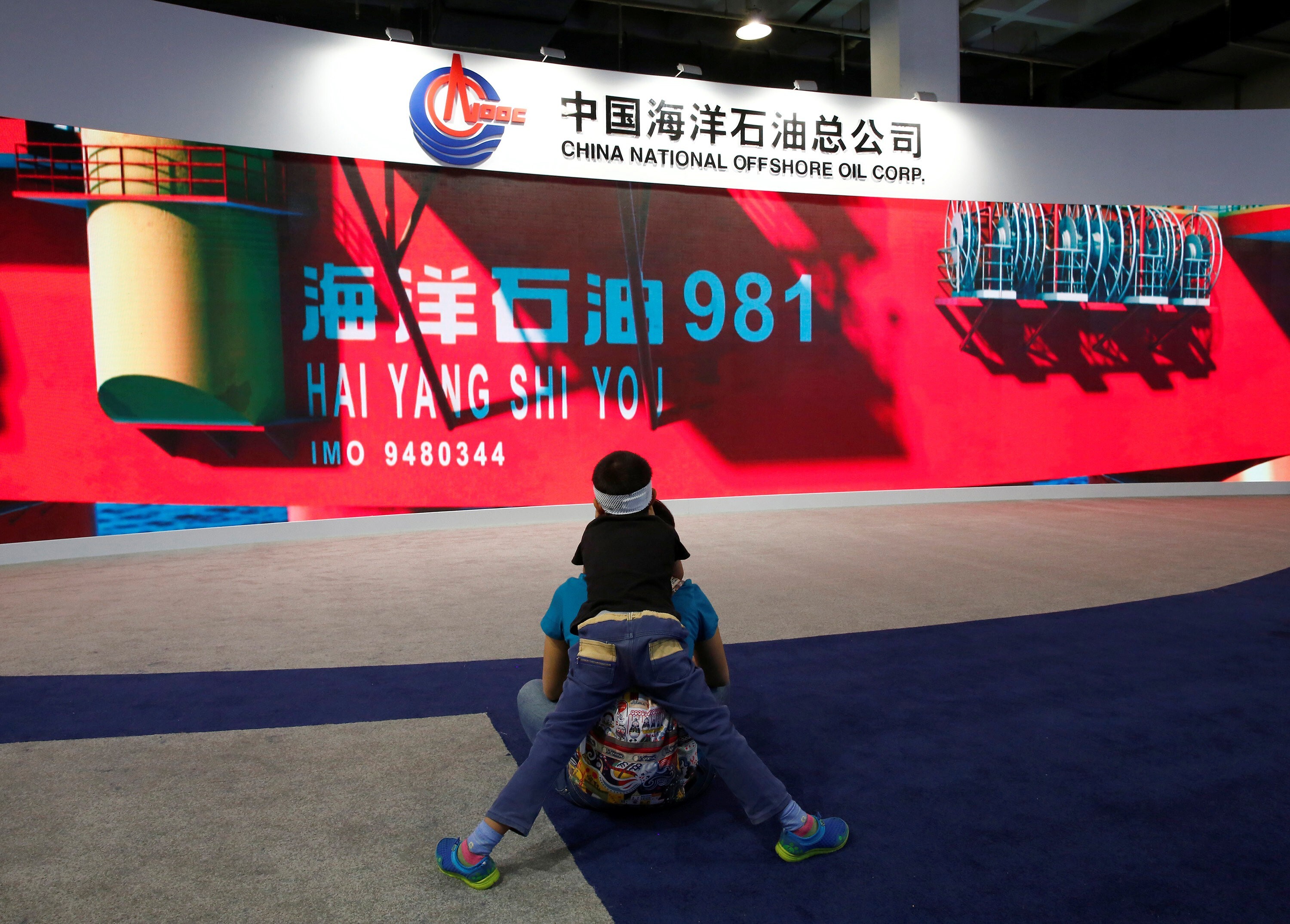 A promotional video about a Chinese oil rig at a booth of China's state-run oil company CNOOC during China Beijing International High-Tech Expo in Beijing, May 16, 2014. Photo: Reuters