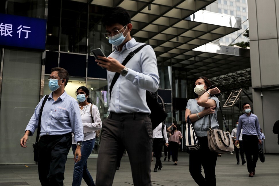 Masked office workers walk through the financial district of Singapore. Photo: EPA-EFE
