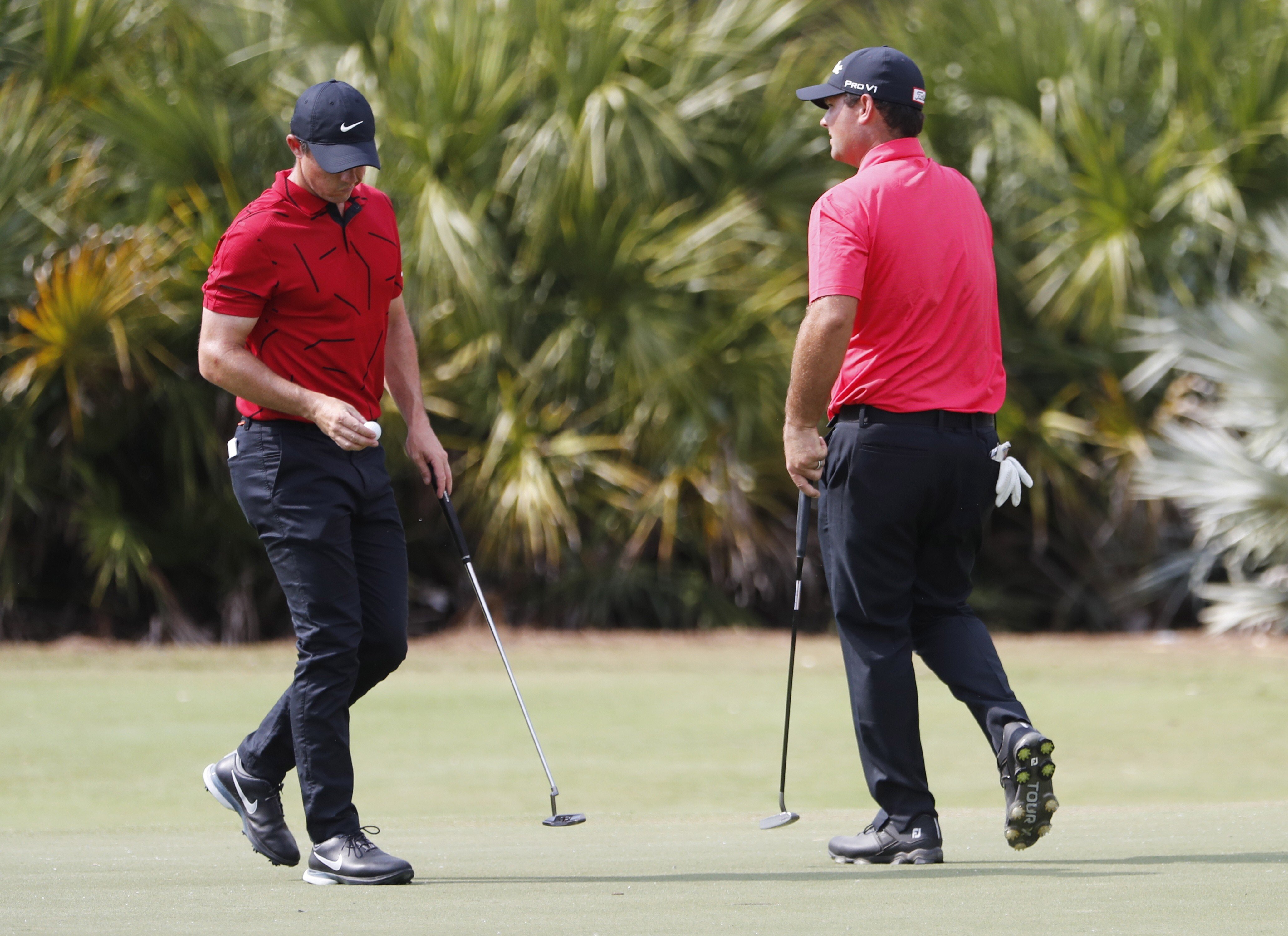 Rory McIlroy of Northern Ireland, left, and Patrick Reed of the US wear a red top and black trousers as a tribute to Tiger Woods on Sunday. Photo: EPA-EFE