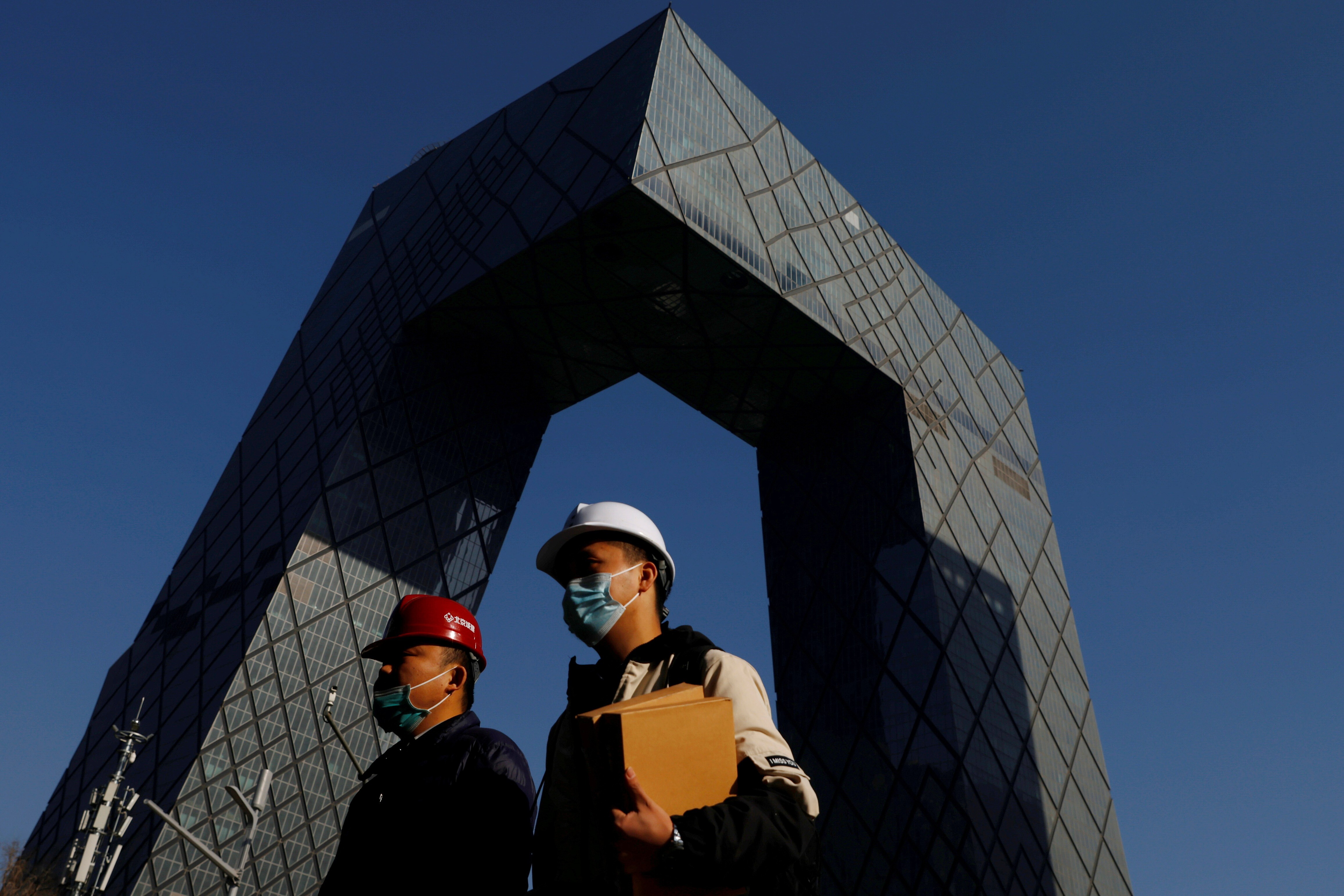 People walk past the CCTV headquarters, home of the Chinese state media outlet and its English-language sister channel CGTN, in Beijing in February. Photo: Reuters