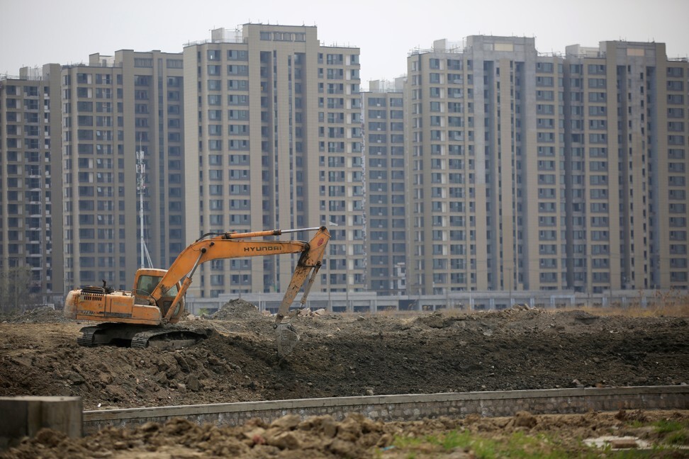 An excavator at a construction site of new residential buildings in Shanghai on March 21, 2016. Photo: Reuters