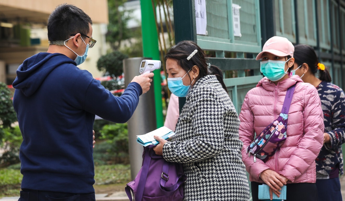 Domestic helpers wait to collect test kits at the Wan Chai Sports Ground amid the fourth wave of coronavirus infections in December. Photo: Xiaomei Chen