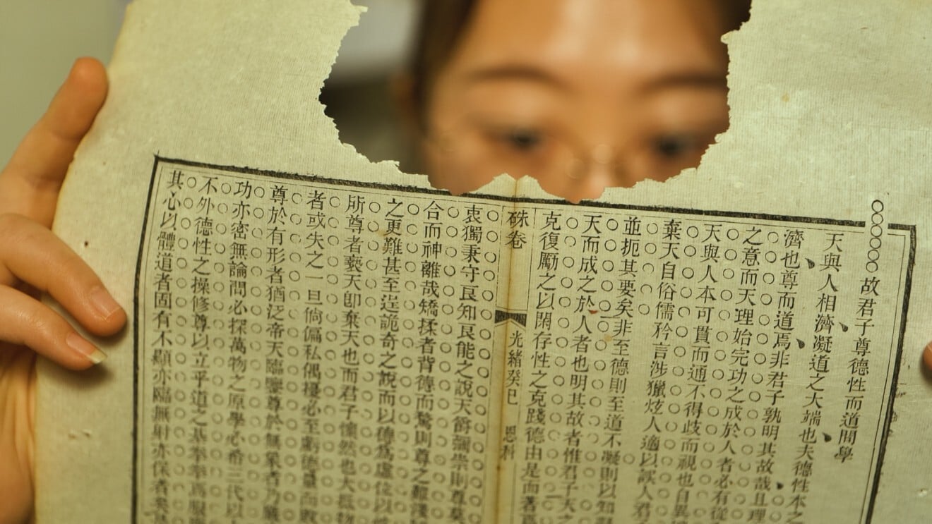 Lian Chengchun examines a torn page at her studio in Beijing. Photo: Patrick Wong