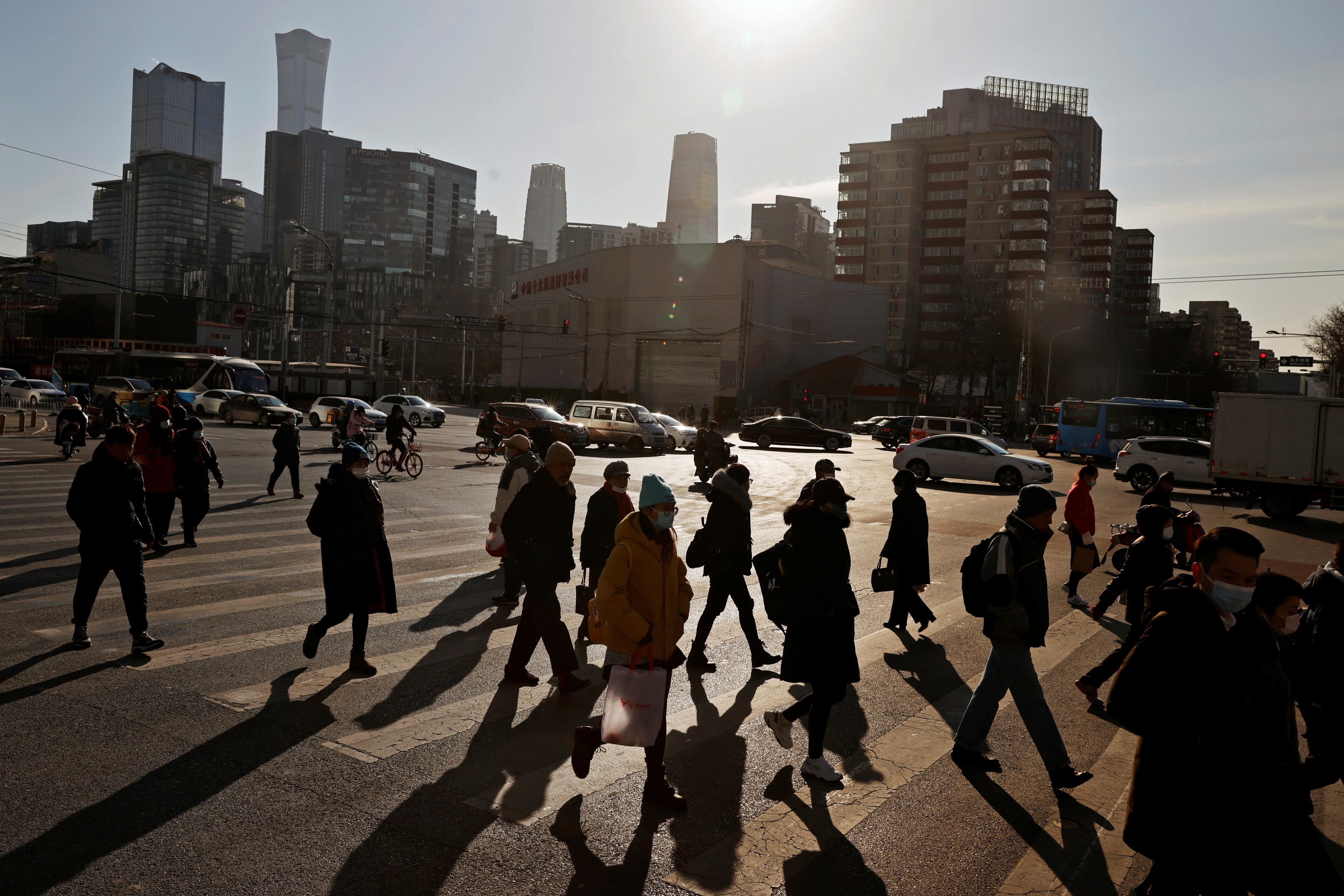 People cross a street during morning rush hour in Beijing’s central business district. Photo: Reuters