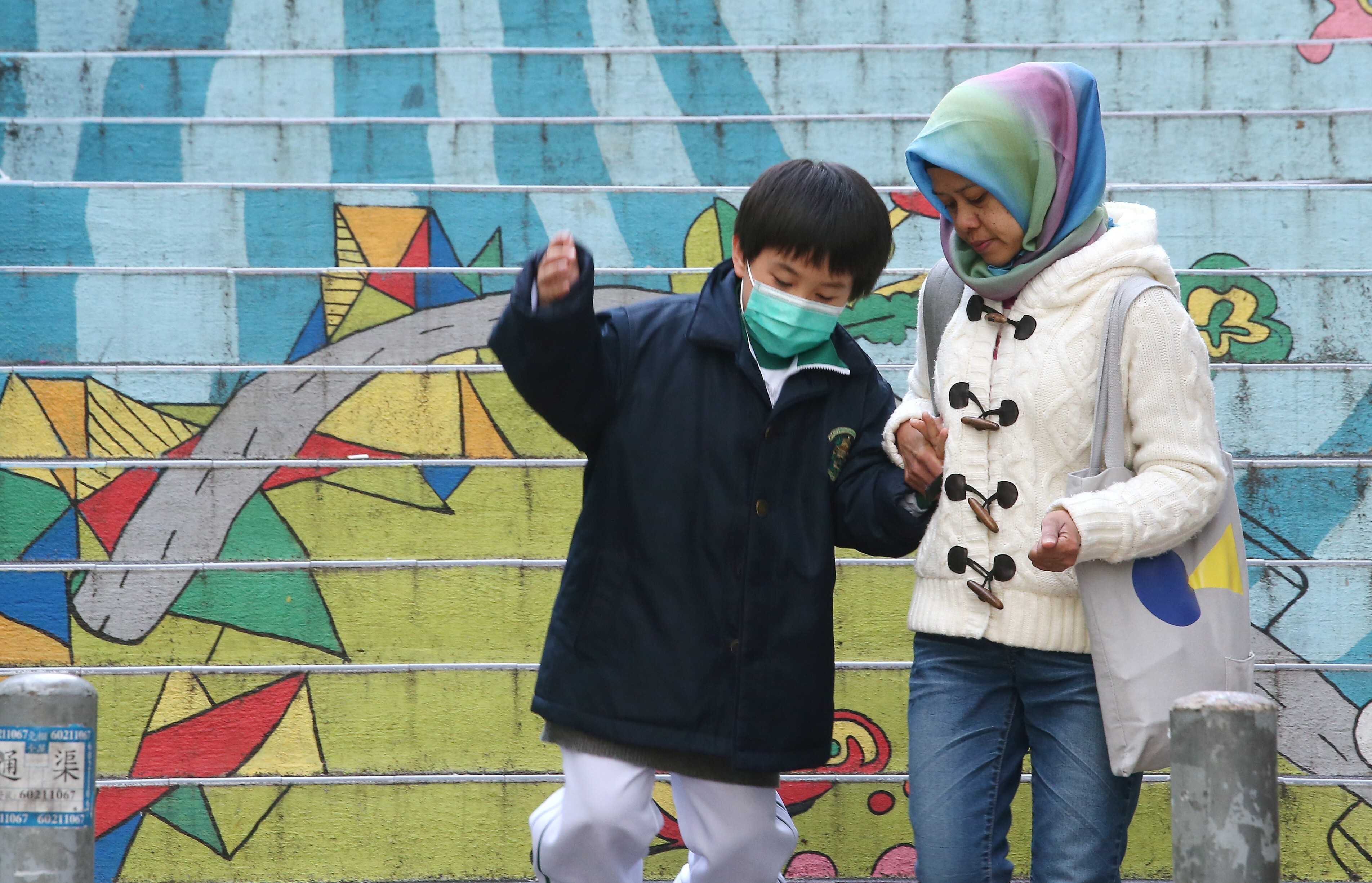A domestic helper walks with a child in her care in February 2018. Given the limited care options for children in Hong Kong, many families rely on migrant workers to help look after their children at home. Photo: David Wong