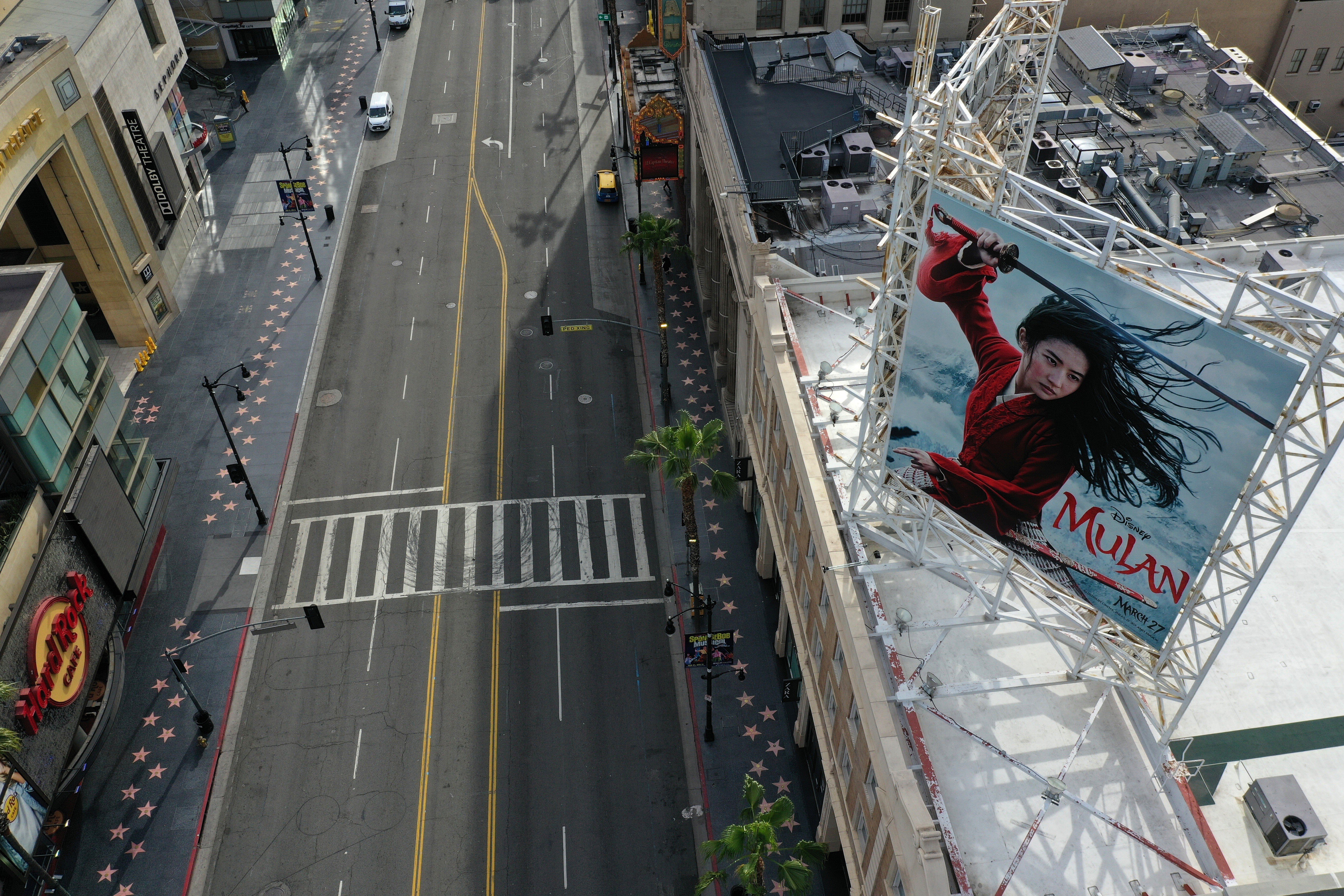 A poster for the Disney movie “Mulan” towers over an empty Hollywood Boulevard in Los Angeles during the coronavirus pandemic in March 2020. Photo: Reuters