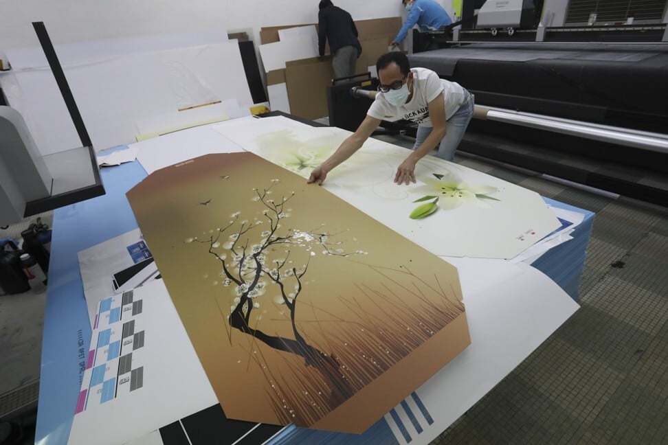 A LifeArt staff member works on a cardboard coffin. Photo: Jonathan Wong