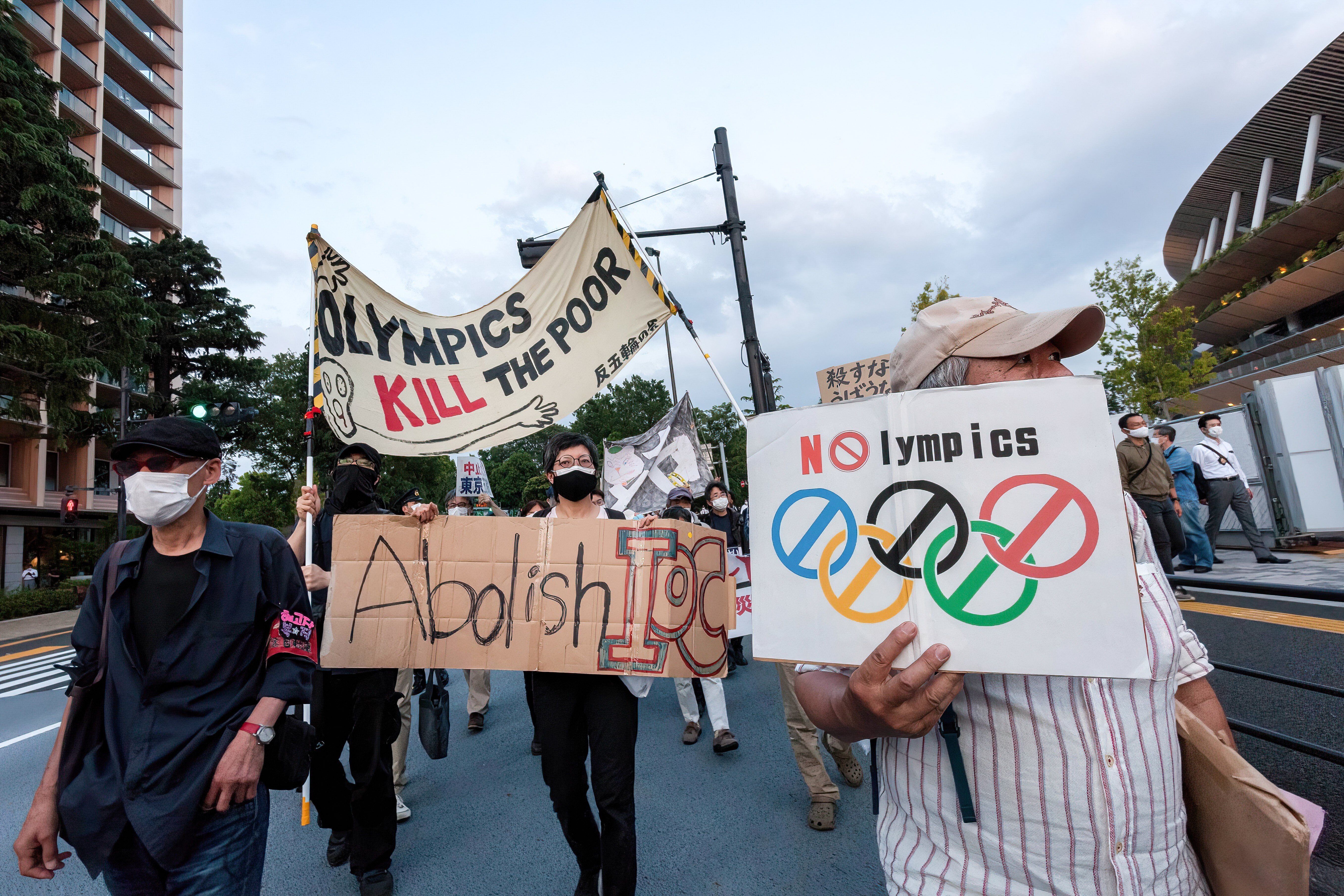 Opposition to the Tokyo Games is becoming more fervent in the host nation as protesters hold up signs while marching in front of Tokyo’s National Stadium. Photo: DPA