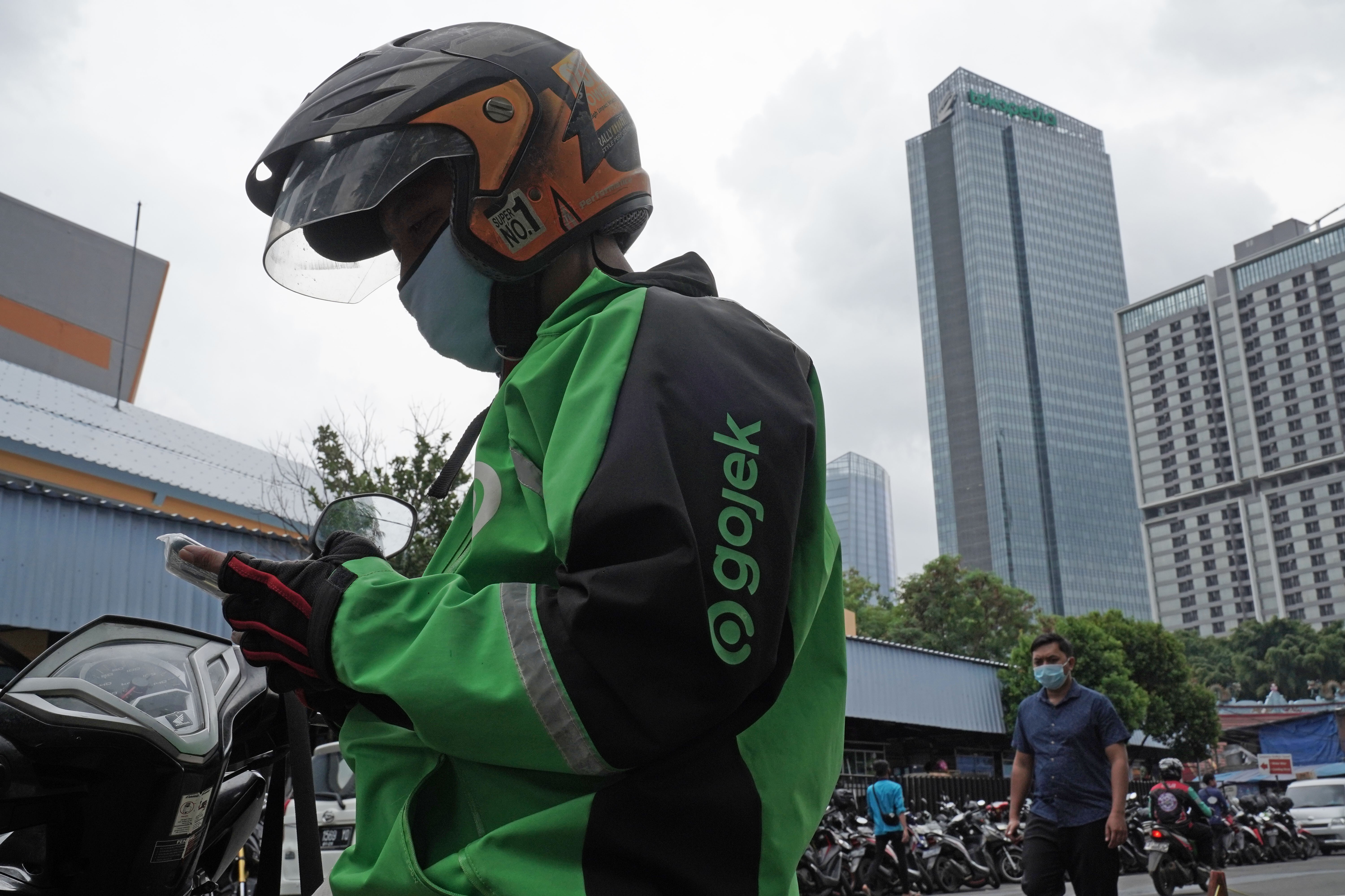 A Gojek driver checks his mobile phone in Jakarta in January. Southeast Asia technology companies Gojek and Tokopedia plan to combine in the biggest merger ever in Indonesia. Photo: Bloomberg