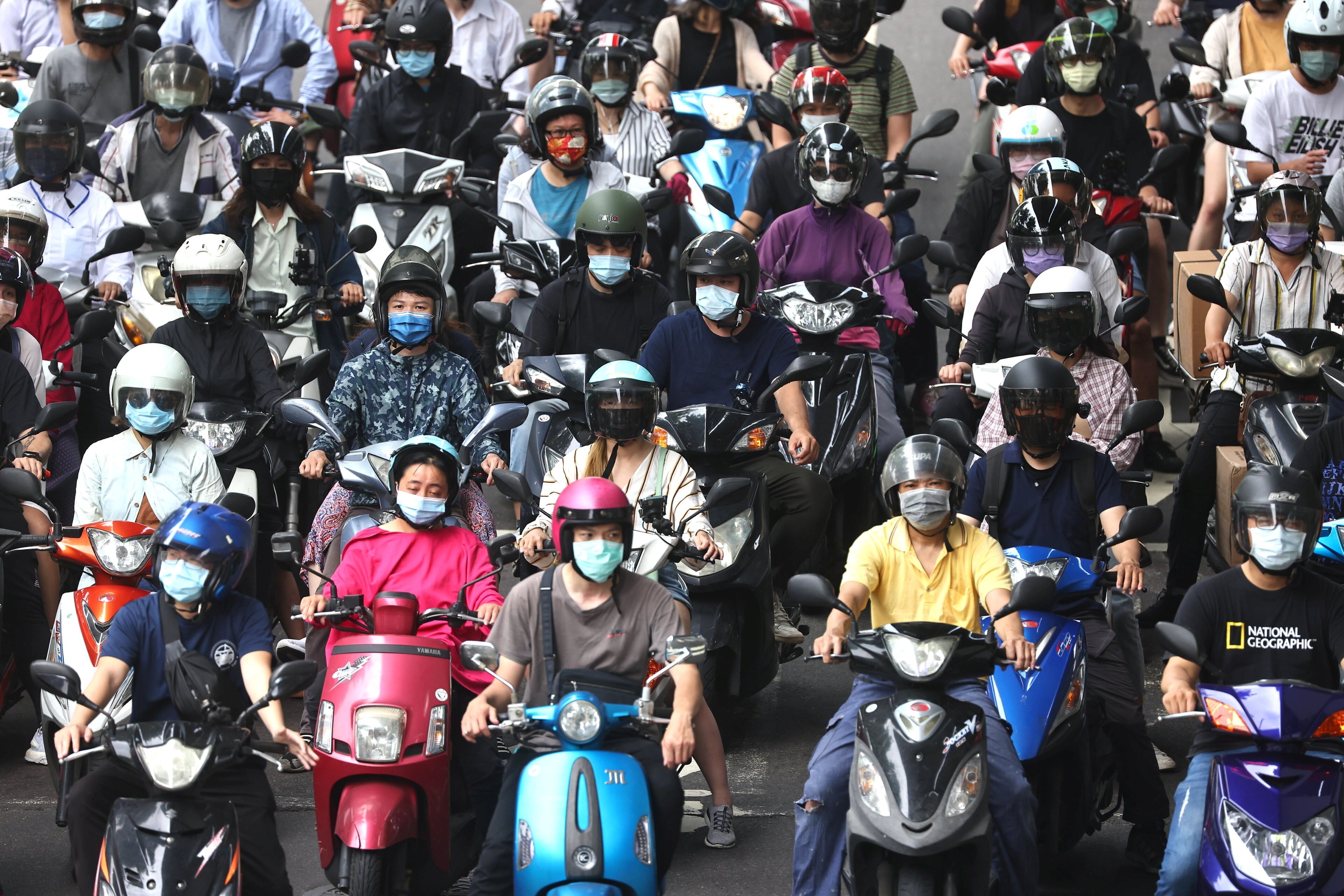 Moped riders in Tapei, Taiwan, wait at a traffic light on May 18. After keeping Covid-19 under control for months, Taiwan is grappling with a recent wave of infections. With many societies still far from achieving herd immunity, we need to be prepared to coexist with the virus over the coming years. Photo: Reuters