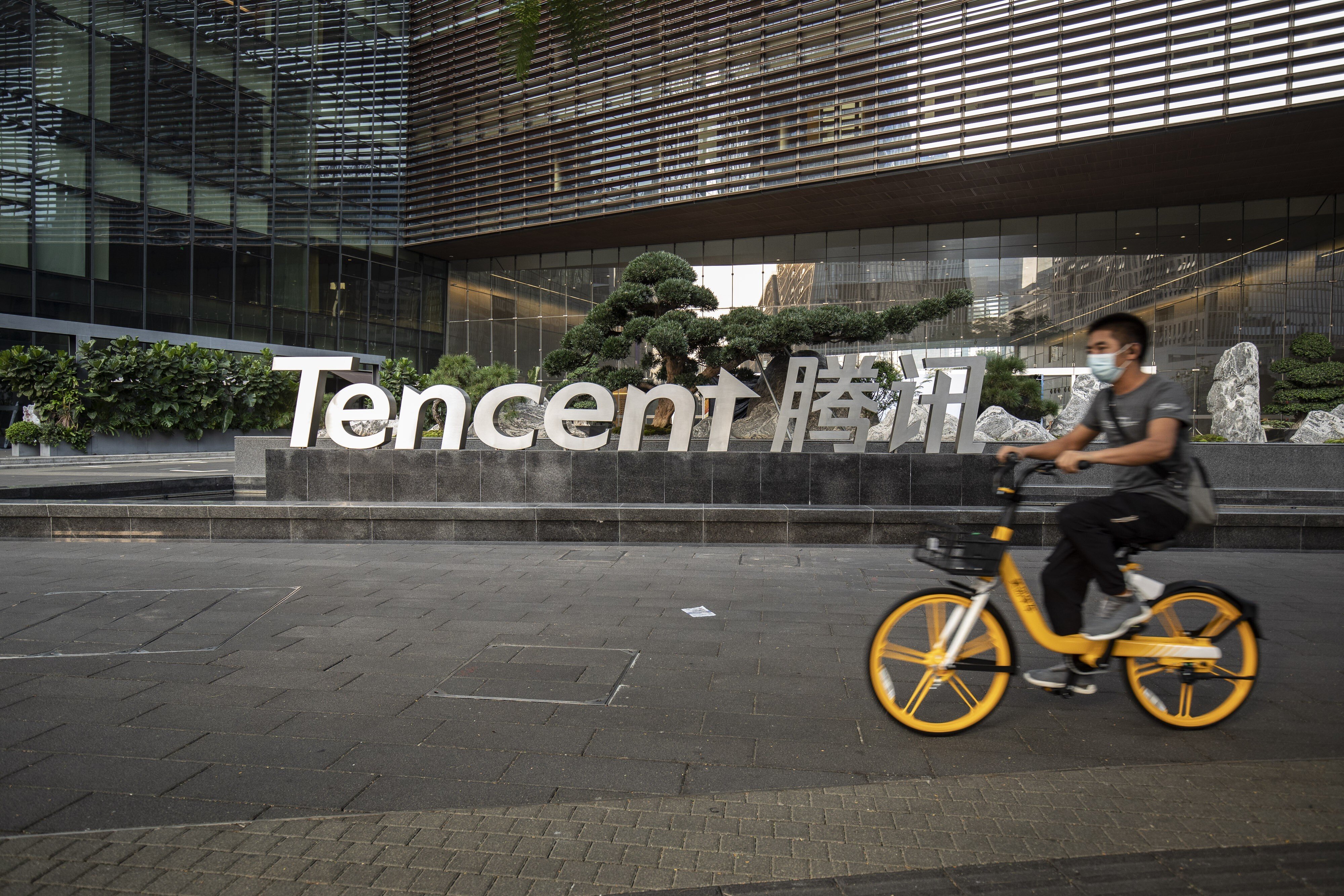 A cyclist wearing a protective mask rides past the Tencent Holding logo at the company's headquarters in Shenzhen on March 20. Photo: Bloomberg