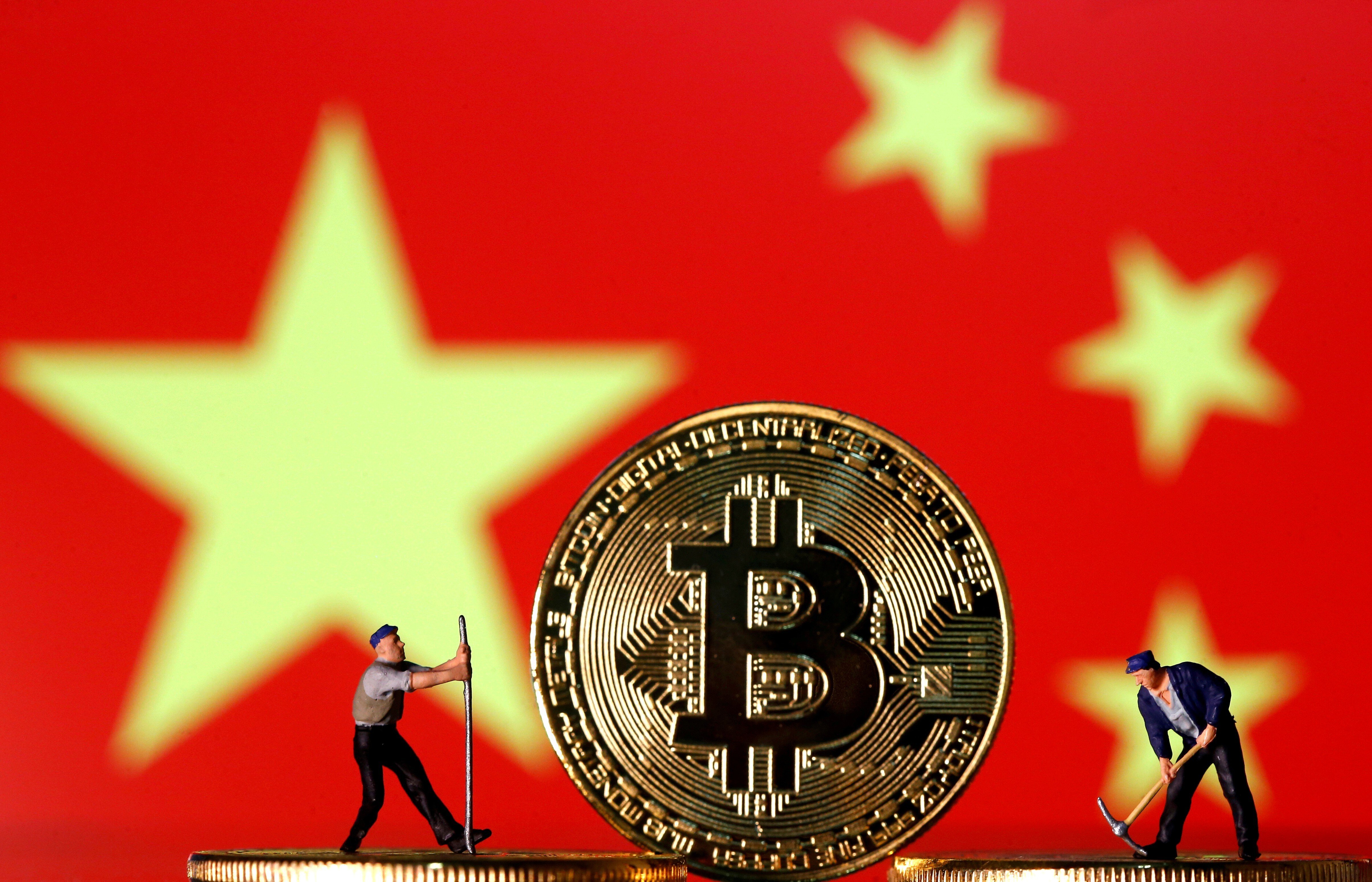 Small toy figurines are seen on representations of the bitcoin virtual currency displayed in front of an image of China's flag. Photo: Reuters