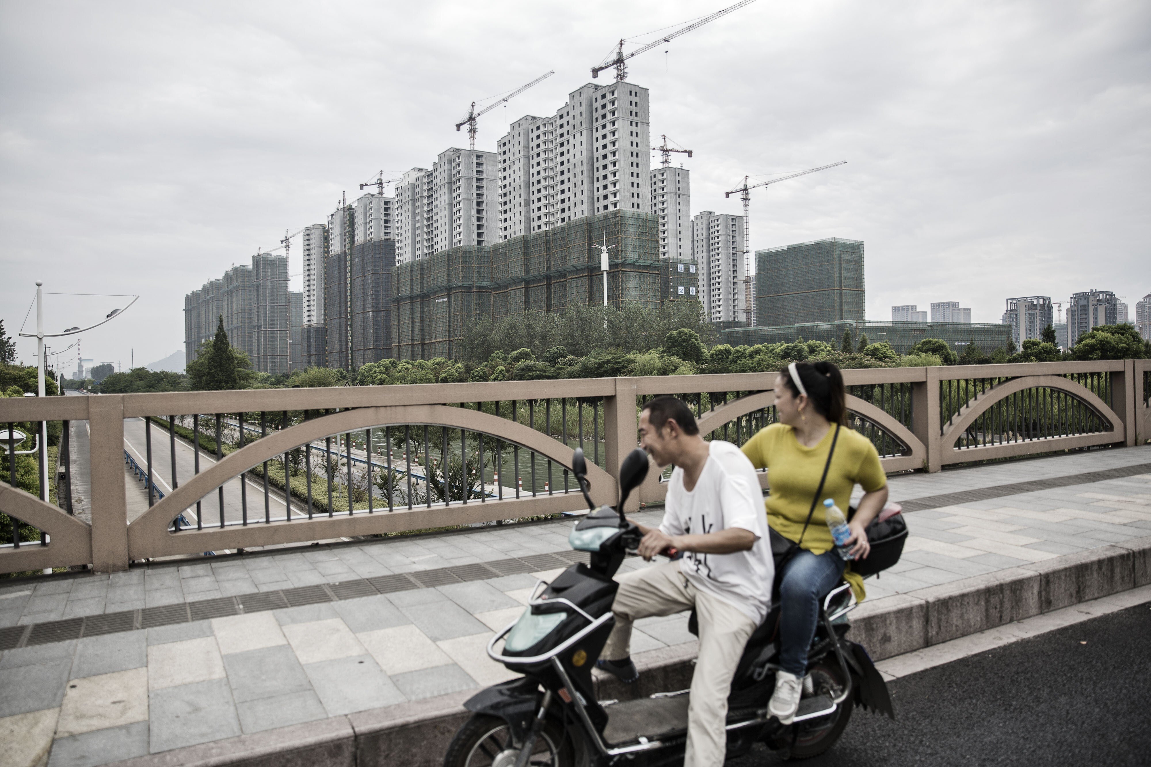 A couple watching apartments under construction in Hangzhou on September 5, 2016. Photo: Bloomberg