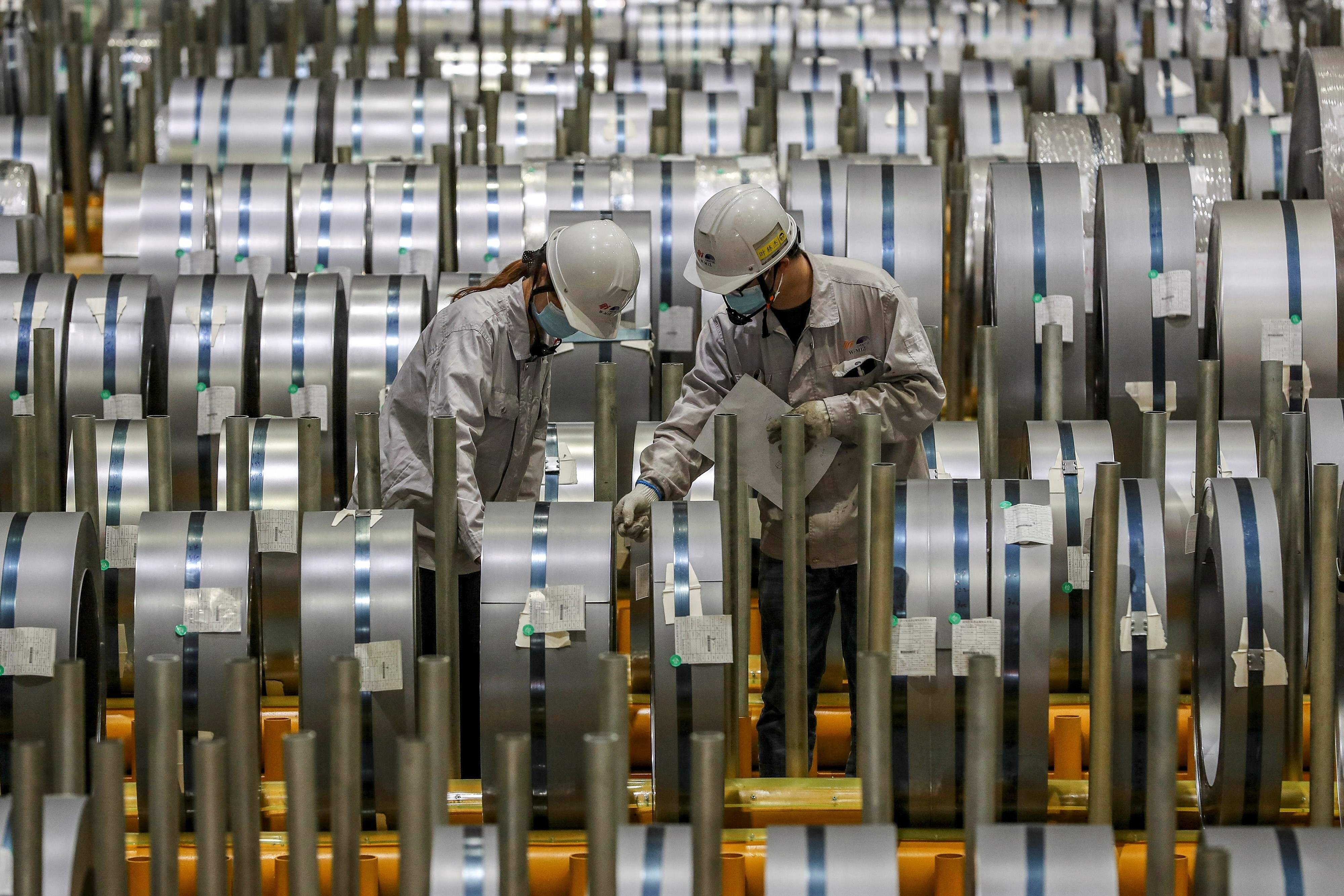 Workers check rolls of sheet aluminium at a factory in Wuhan, in central Hubei province, on May 8. China’s 14th five-year plan emphasises the development of the manufacturing industry, which can help prompt more migrant workers to shift to higher productivity jobs in that sector. Photo: AFP
