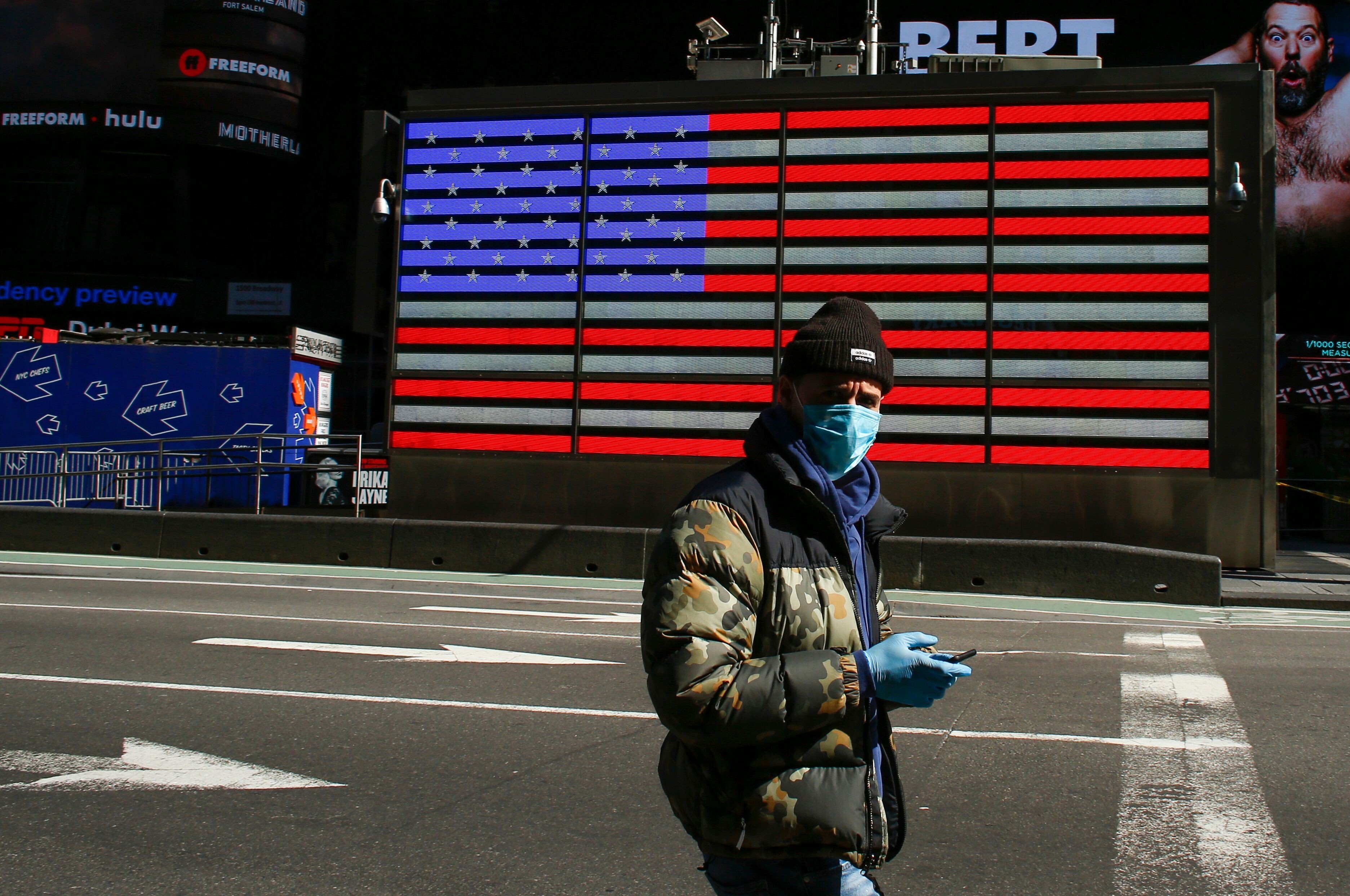 A man wearing a mask checks his phone in Times Square in New York on March 22, 2020. Technology has fragmented the media landscape, fuelling a preference for “personalised” information. In this environment, neutral reporting doesn’t attract as much attention as inflammatory reporting. Photo: AFP