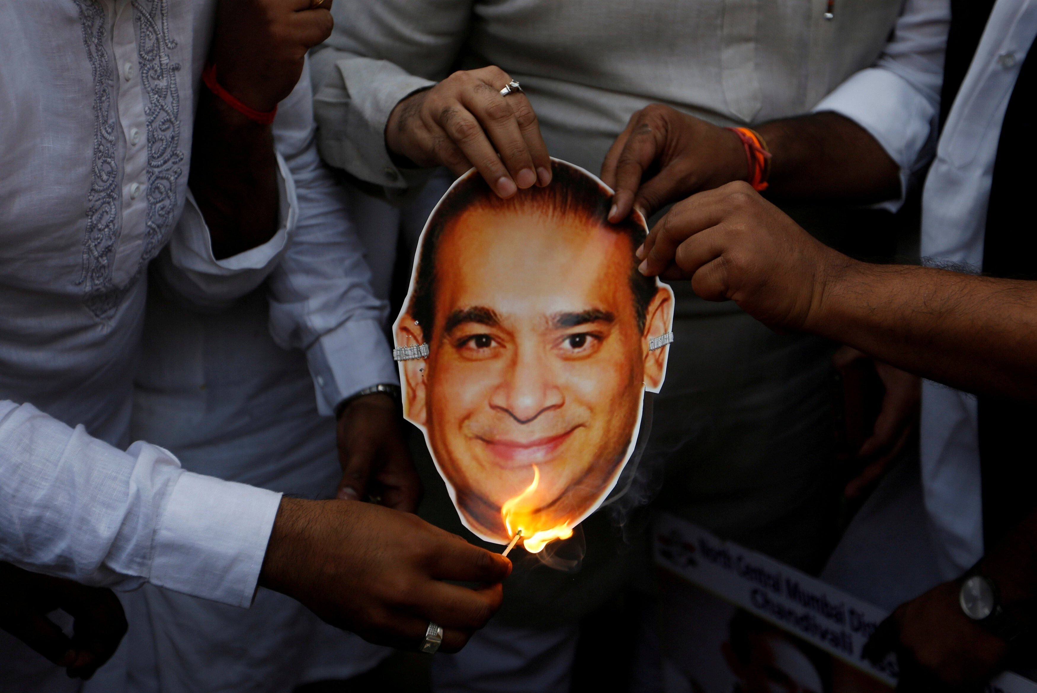 Activists burn a cut-out showing an image of billionaire Indian jeweller Nirav Modi – who alongside his uncle Mehul Choksi is wanted in India over the US$2 billion Punjab National Bank fraud – during a protest in Mumbai in 2018. Photo: Reuters