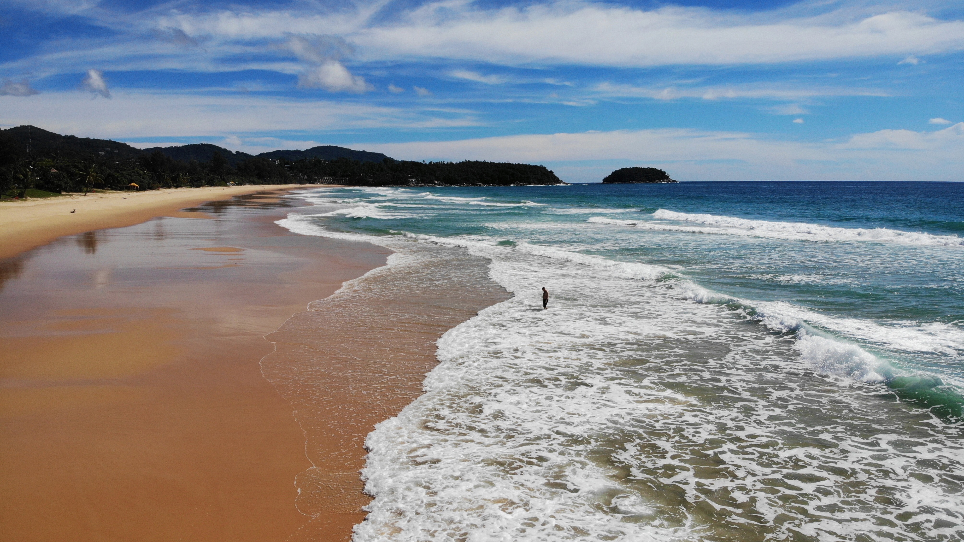 A man walks along an unusually quiet Karon beach in Phuket on September 30, 2020. Photo: AFP