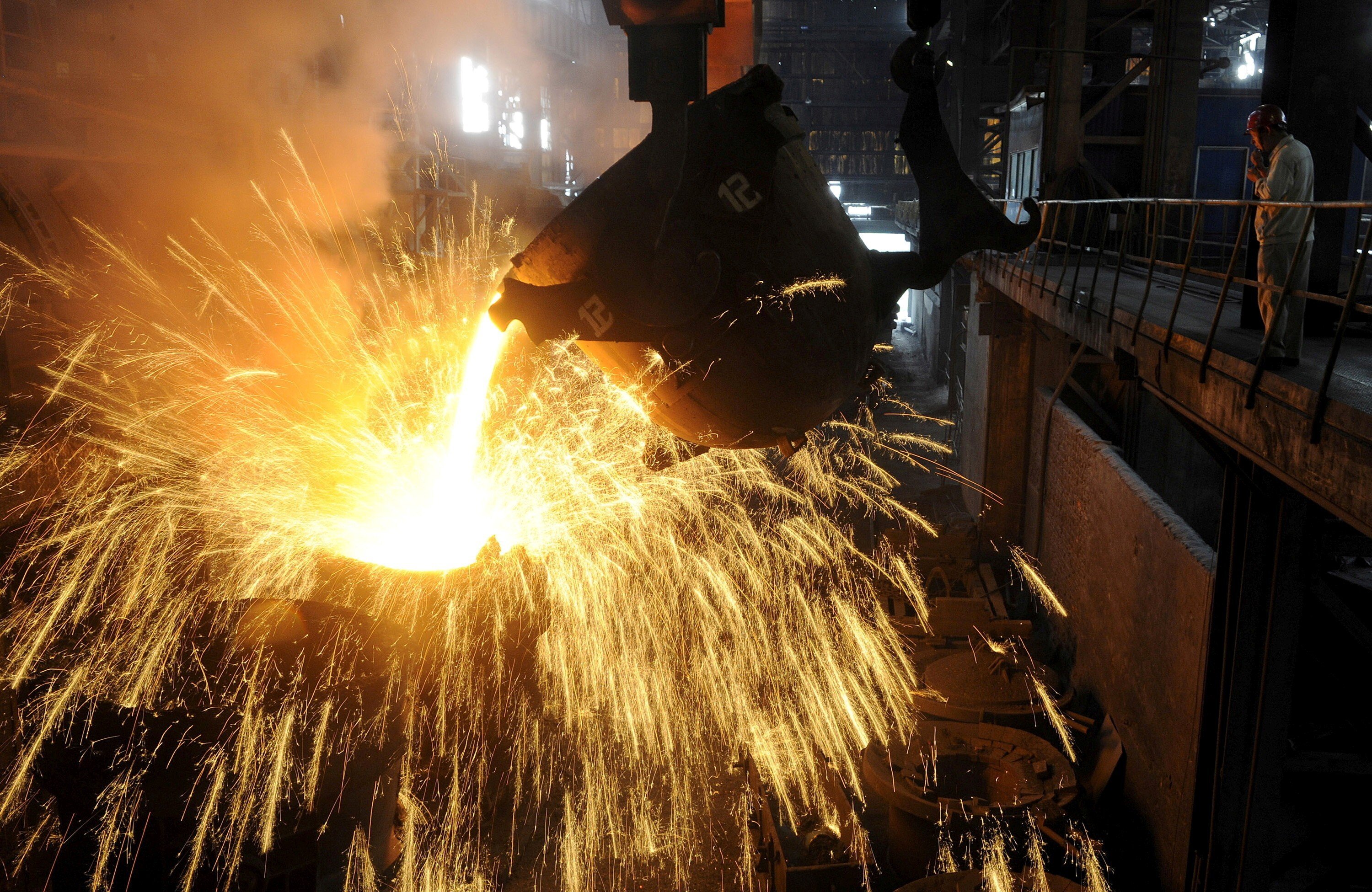 An employee monitors molten iron being poured into a container at a steel plant in Hefei, Anhui province in September 2013. Photo: Reuters