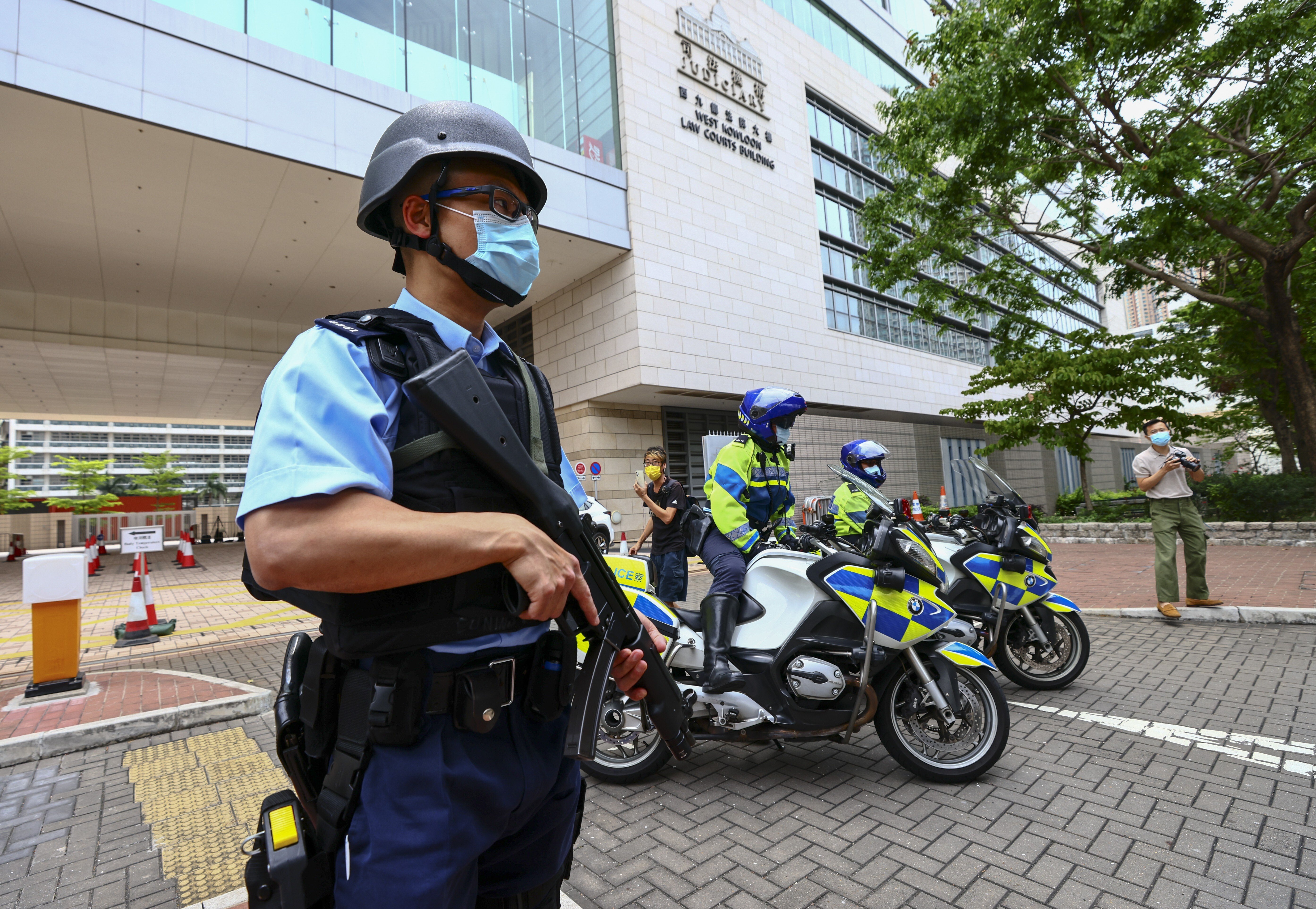 Police officers stand guard outside West Kowloon Magistrates’ Courts on March 7 before the arrival of an activist charged under the national security law. Photo: Dickson Lee