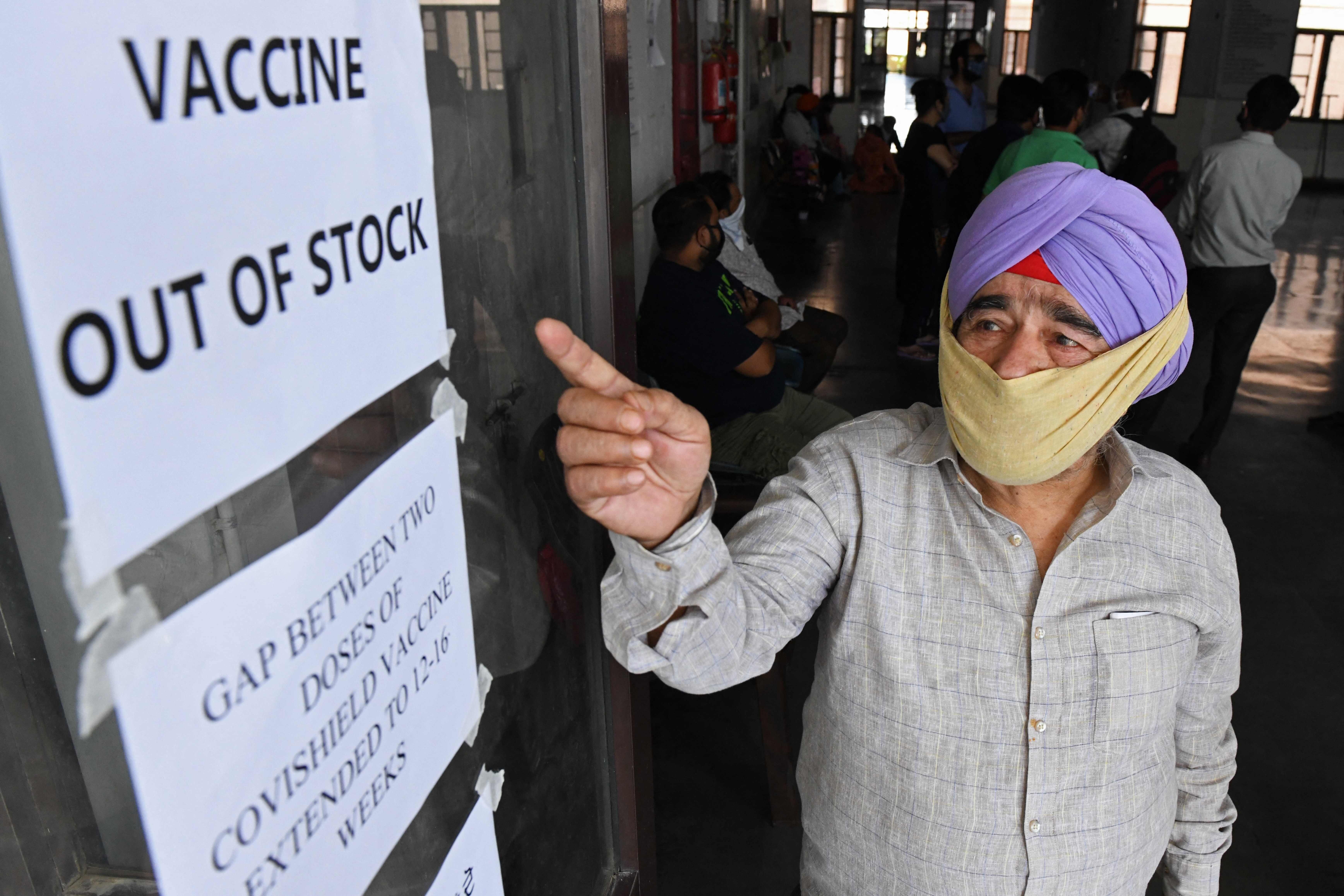 A man points to notices displayed in a hospital indicating that coronavirus vaccines are out of stock, in Amritsar, India, on May 17. Photo: AFP