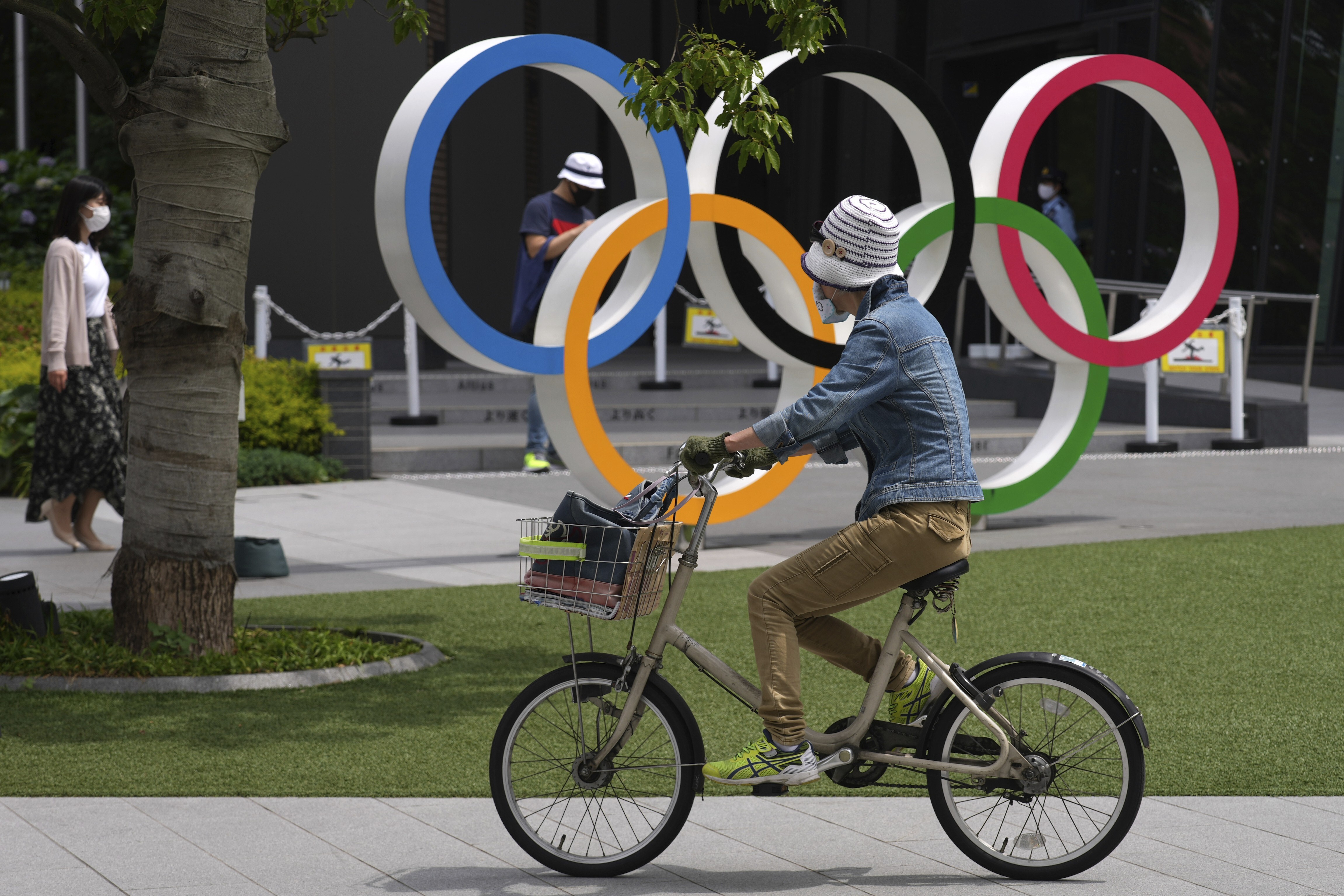 A woman rides a bicycle near the Olympic Rings in Tokyo. Photo: AP