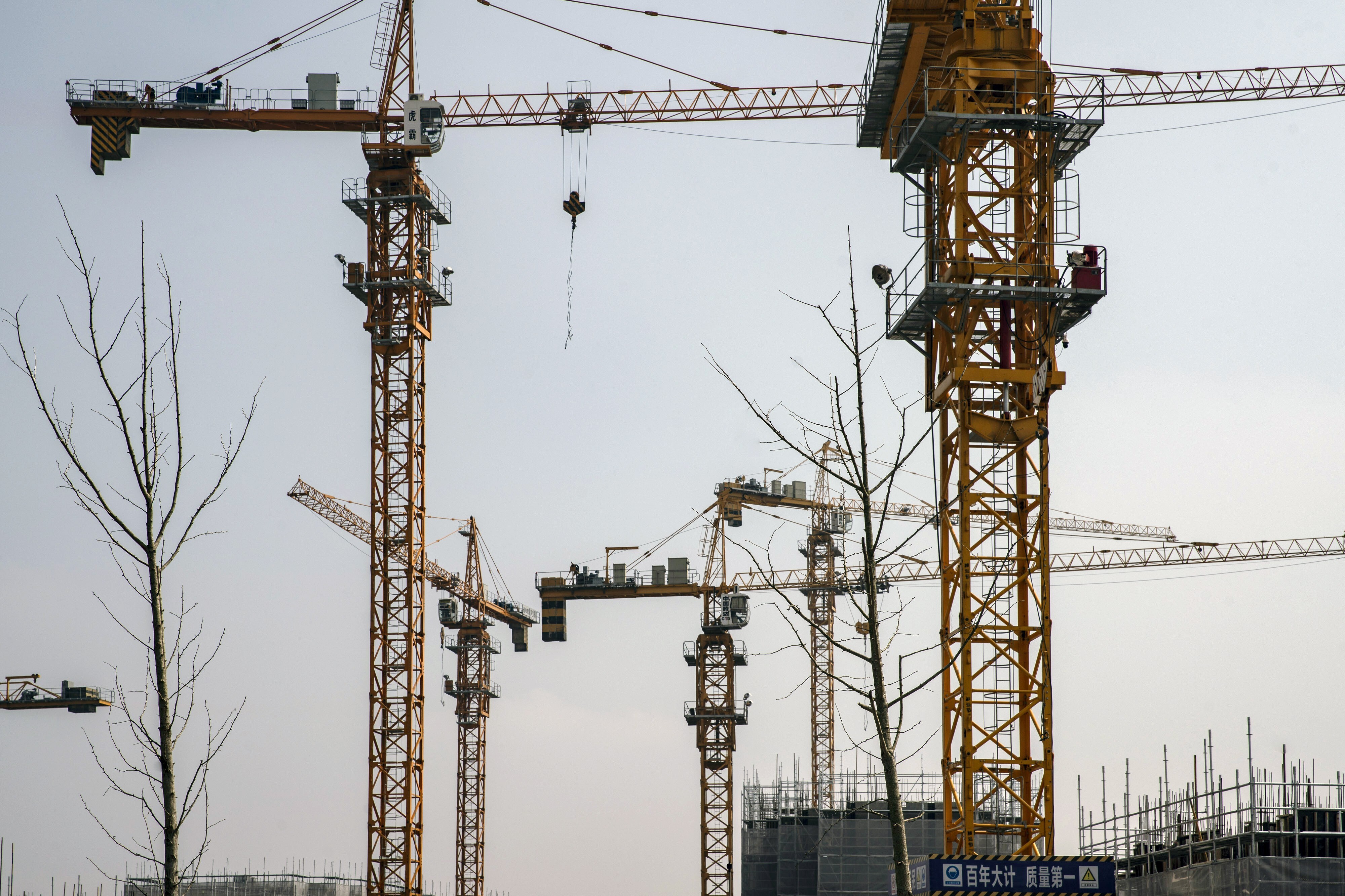 Cranes are seen at a construction site for a residential development on the outskirts of Shanghai on March 14. More land is being made available in the hope of curbing price rises. Photo: Bloomberg