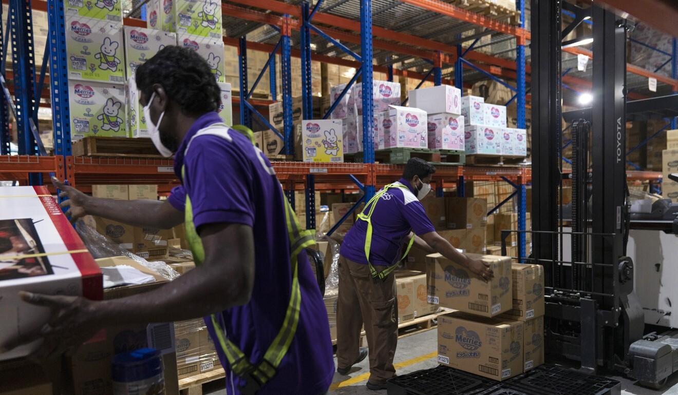 Workers move goods for delivery in a Q100 warehouse in Singapore. The pandemic has driven an e-commerce boom in Southeast Asia, but access to the internet remains uneven across the region. Photo: Bloomberg