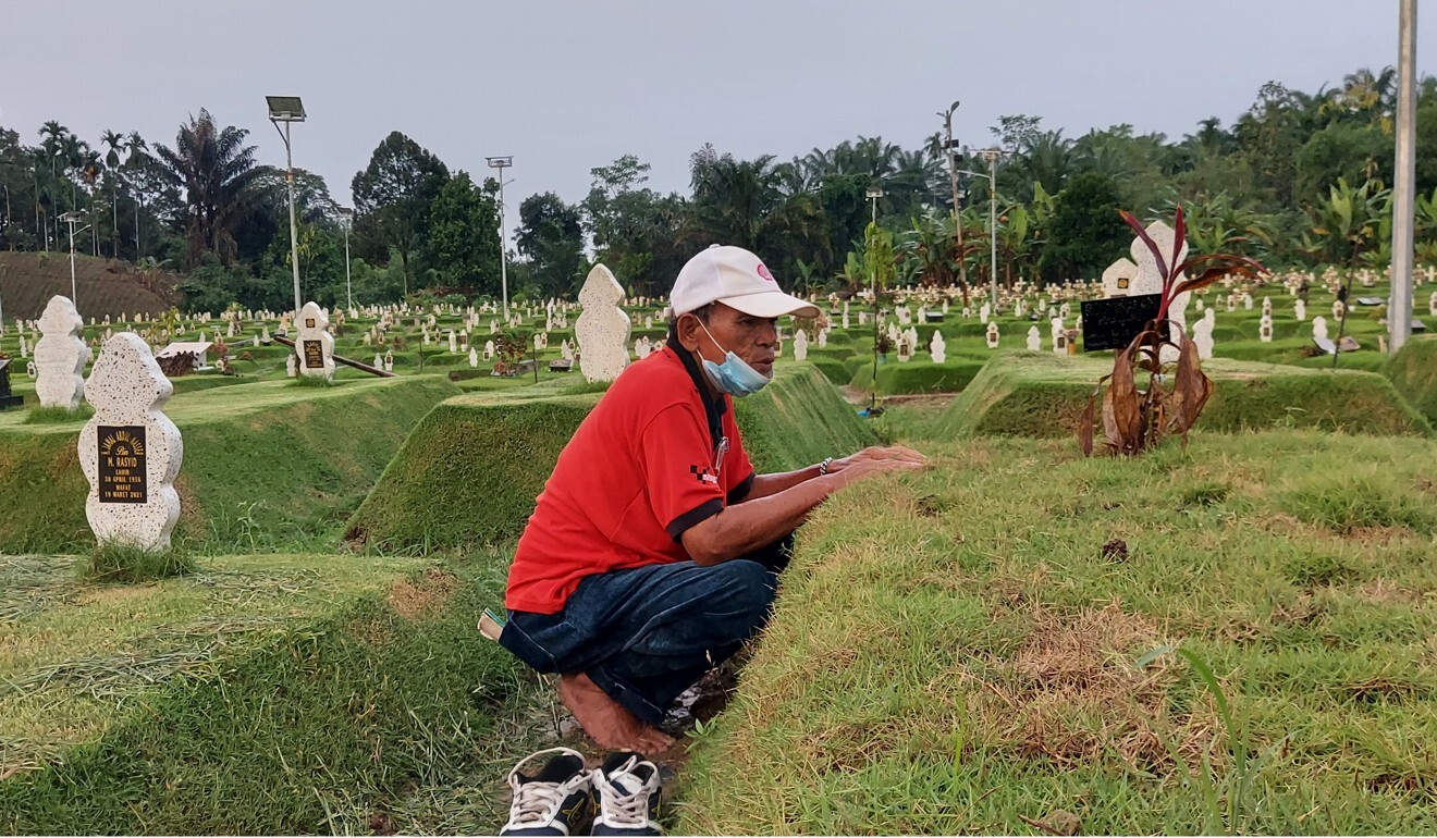 Marahlaluan Rambe talks to his wife Rosminah Hasibuan at her grave at Meda’s Covid-19 cemetery. Photo: Aisyah Llewellyn