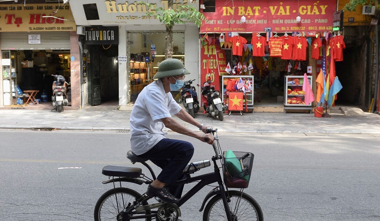 A man in Hanoi rides a bike on an empty street amid the coronavirus pandemic. Photo: Reuters