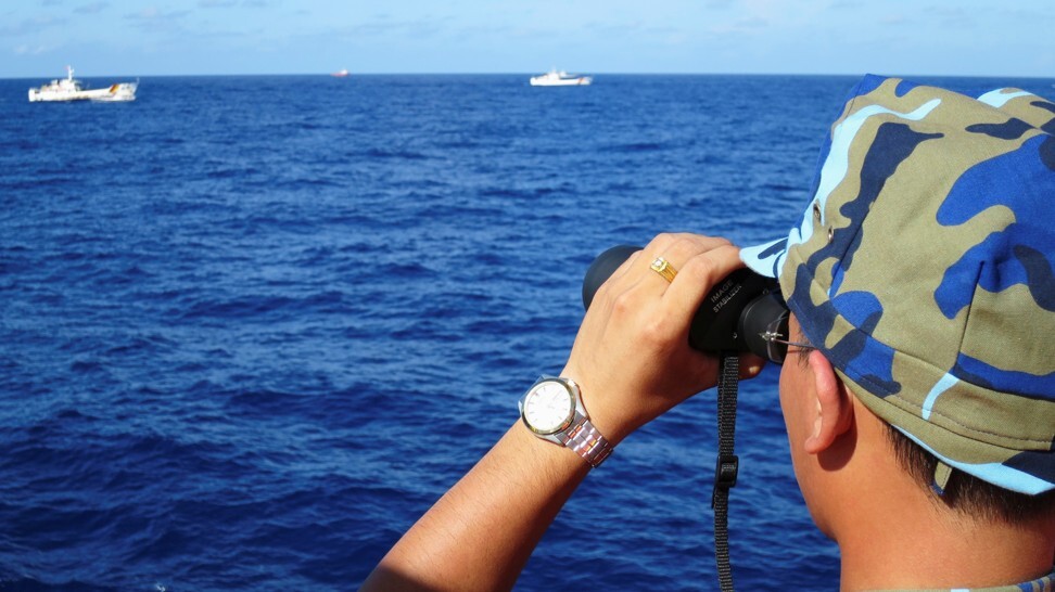 A Vietnamese coastguard officer looks out at Chinese coastguard vessels in the South China Sea. File photo: Reuters