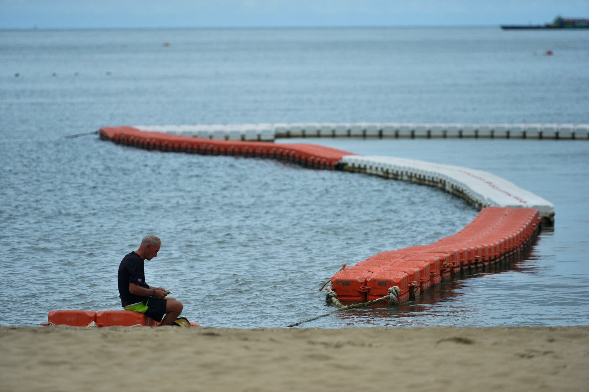 A solitary man sits on the Pattaya beach. Photo: Xinhua
