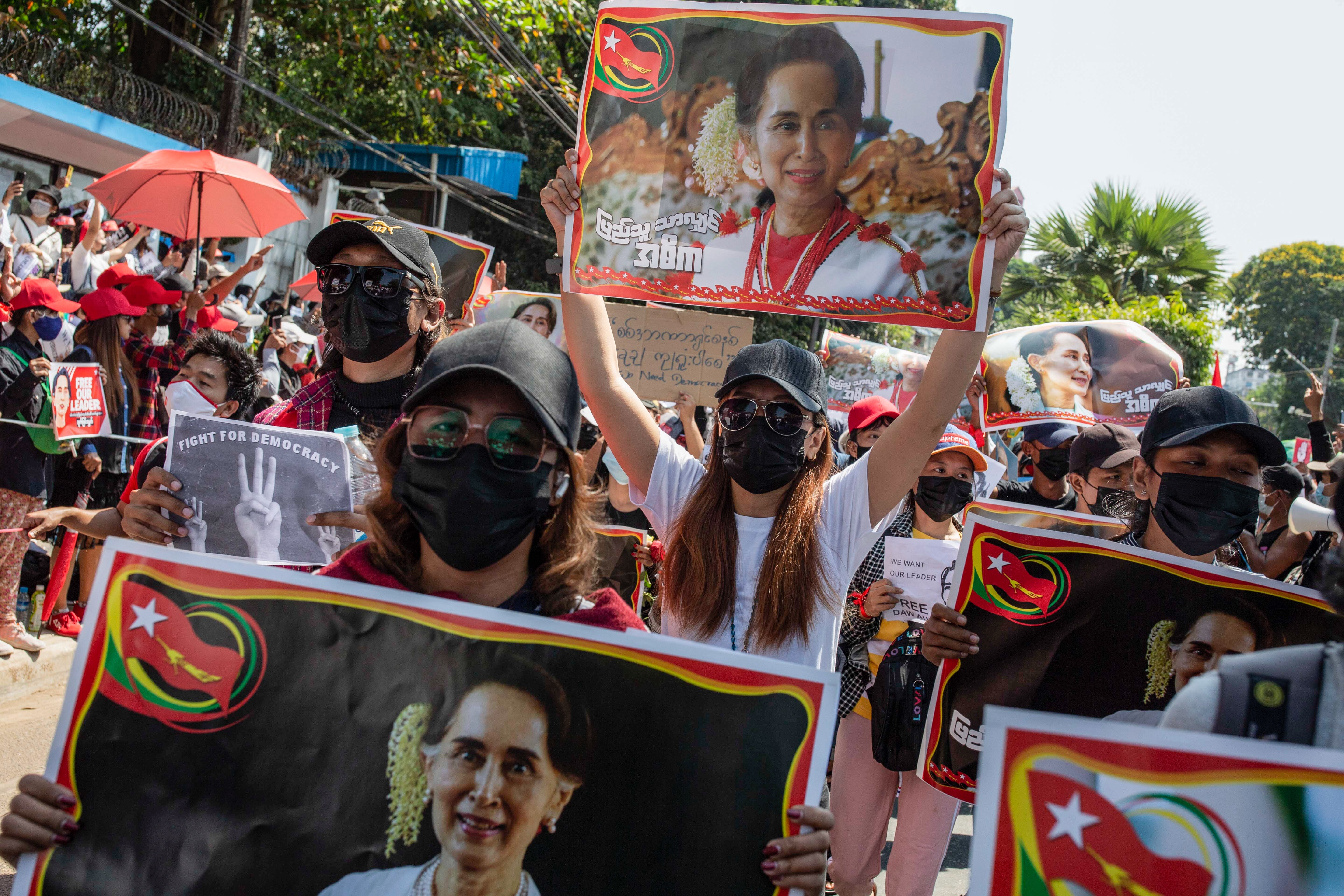 Protesters hold placards with portraits of Aung San Suu Kyi during a demonstration in February. Photo: TNS