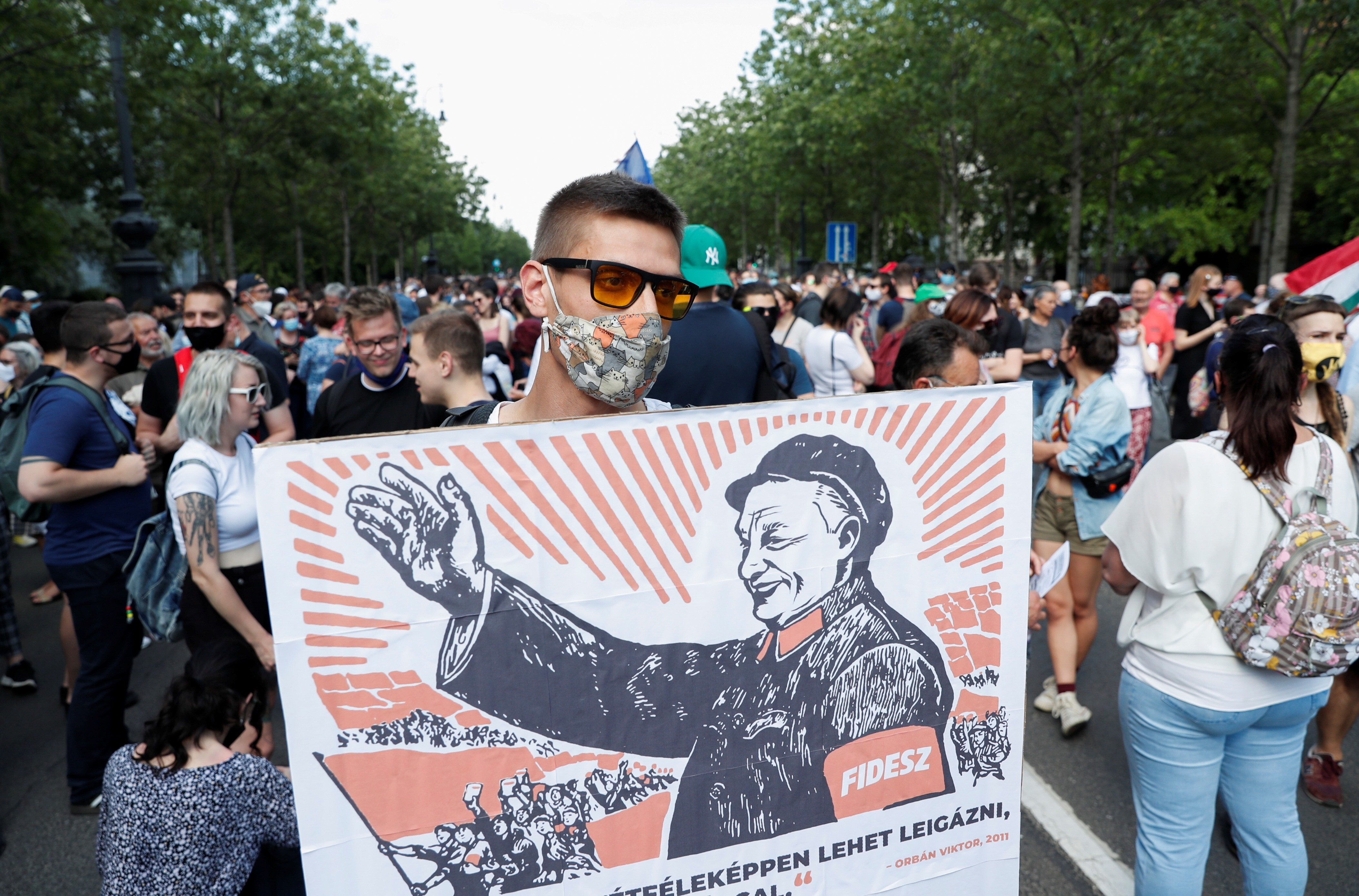 A protester holds a placard depicting Hungary’s Prime Minister Viktor Orban as Mao Zedong during a protest on June 5 against a planned Fudan University campus in Budapest. Photo: Reuters