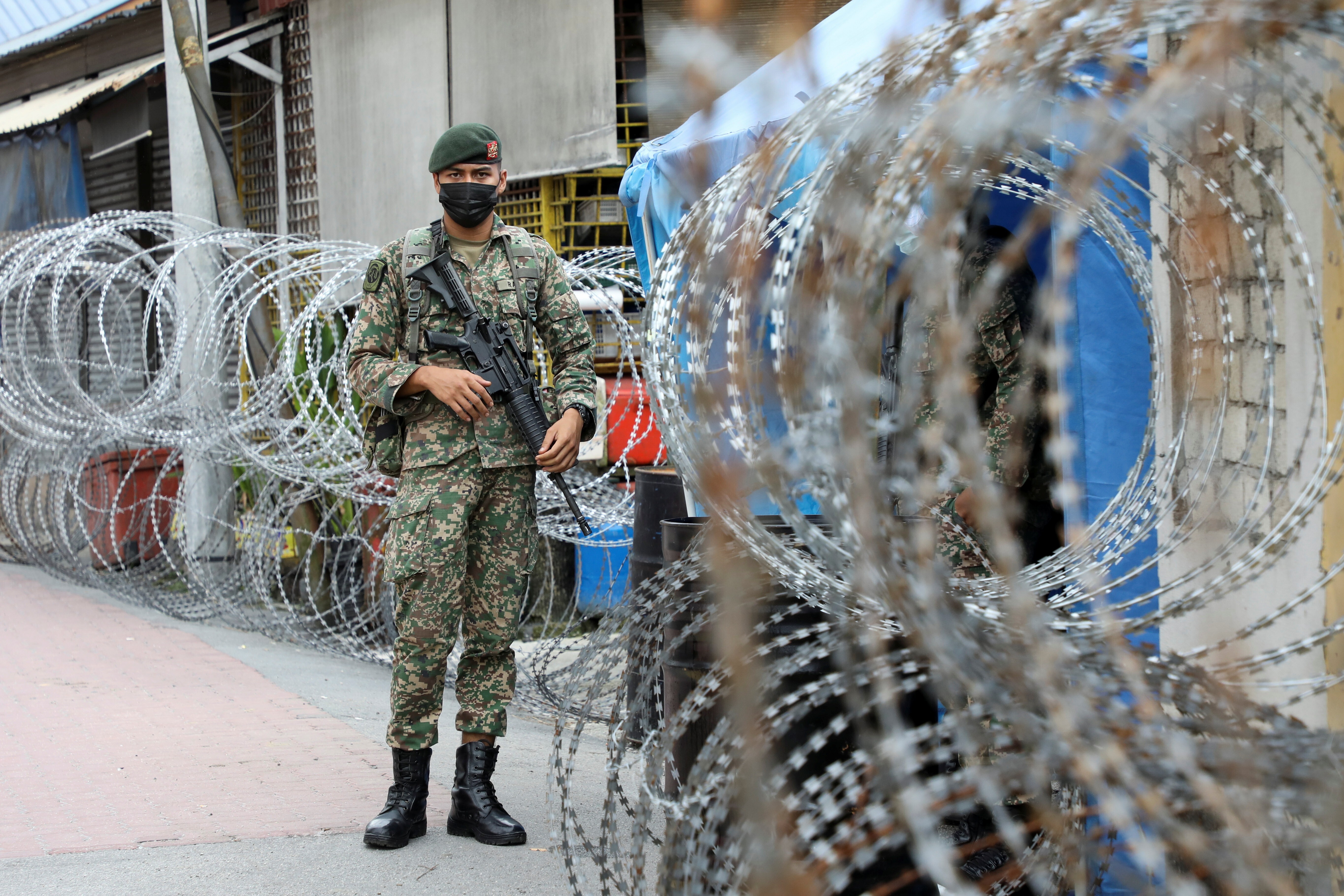 A soldier stands guard outside an area under enhanced coronavirus lockdown in Kuala Lumpur on Tuesday. Photo: Reuters