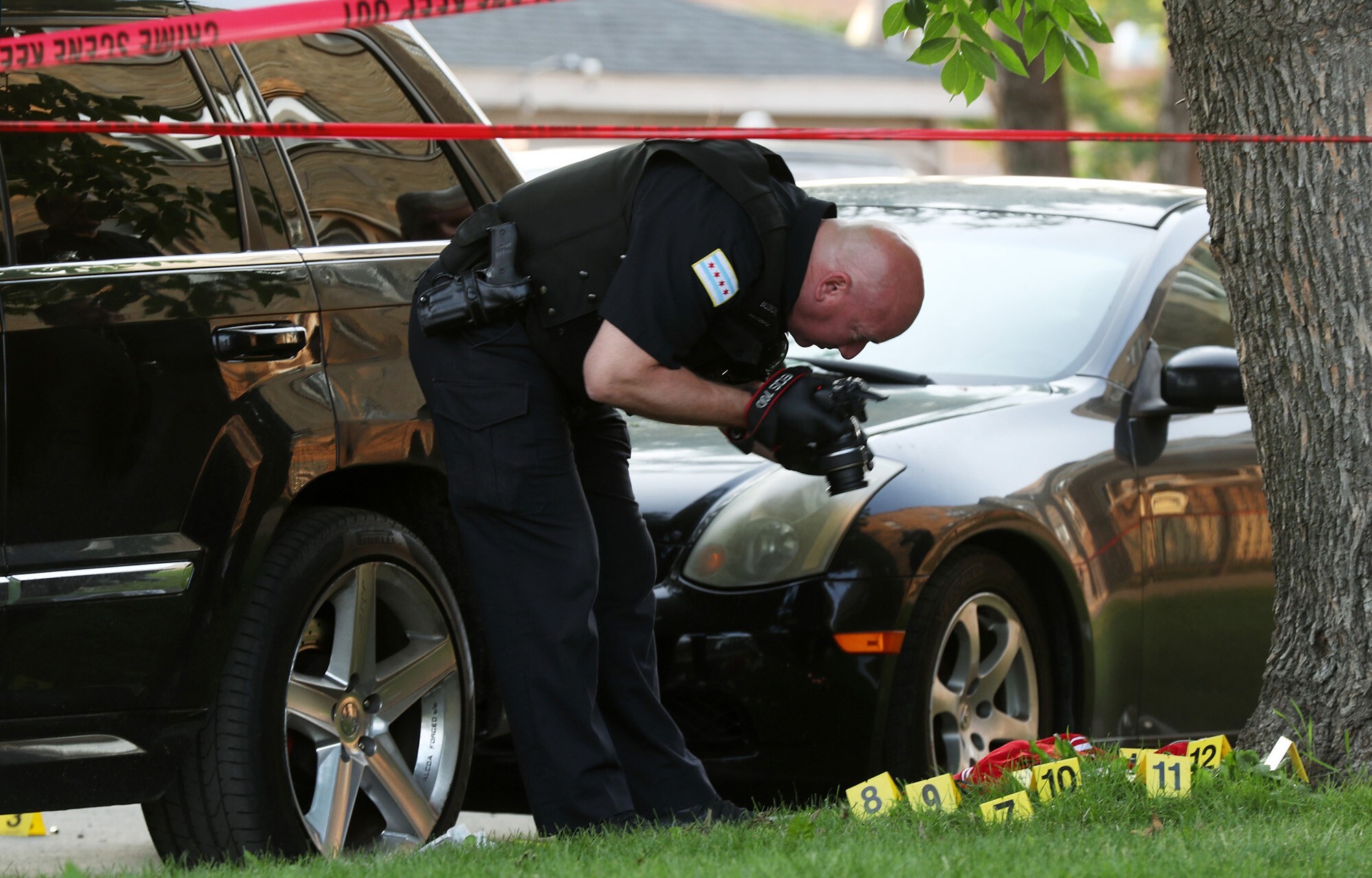 A police officer photographs bullet casings at the scene of a fatal shooting in Chicago. Photo: Chicago Tribune / TNS