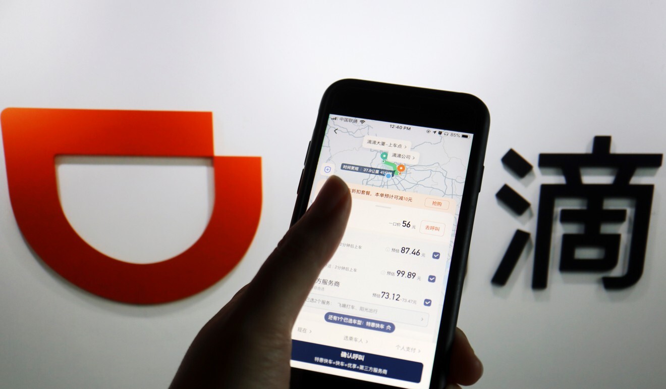 The app of Chinese ride-hailing giant Didi is seen on a mobile phone in front of the company logo. Photo: Reuters