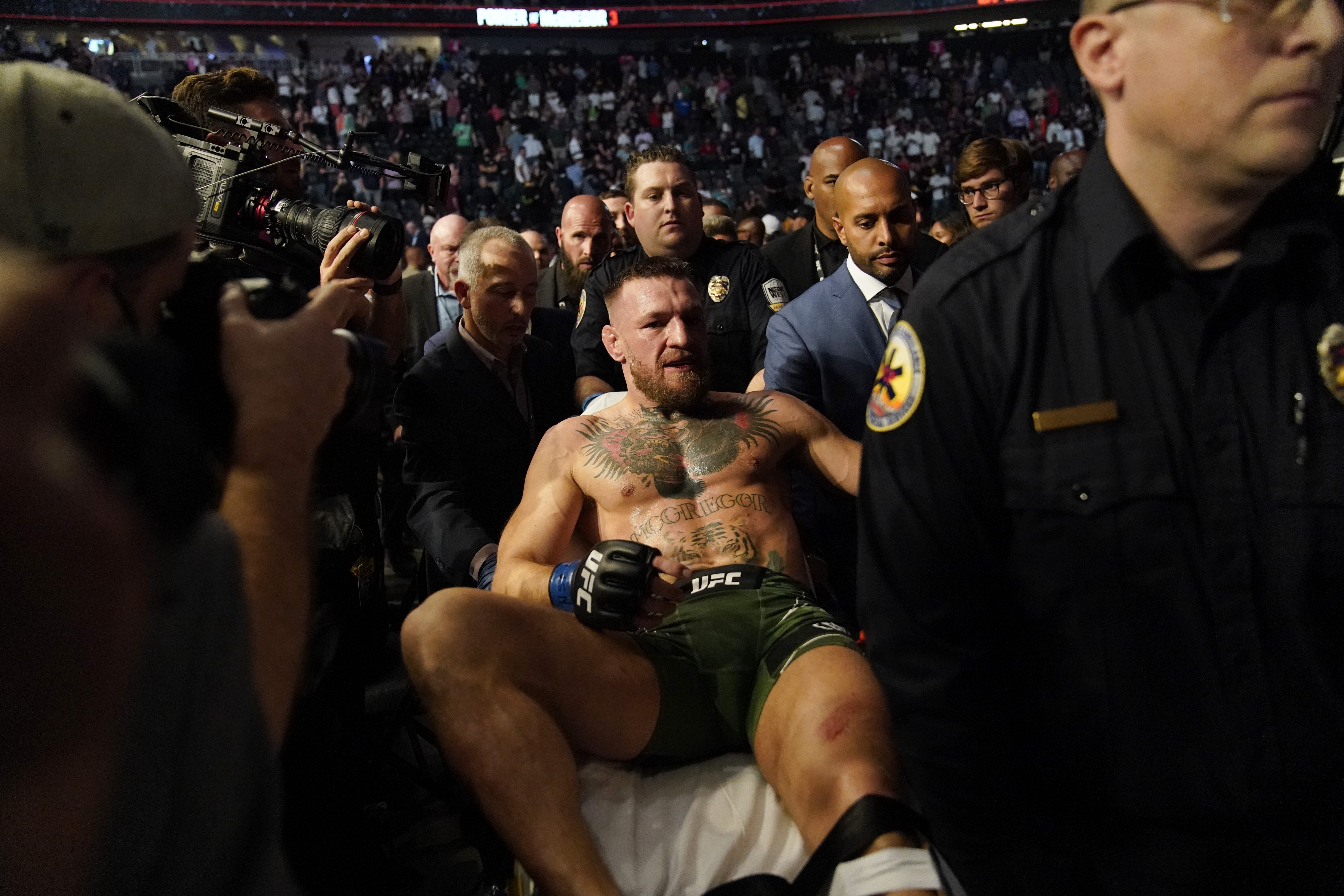 Conor McGregor is carried off on a stretcher after losing to Dustin Poirier in their UFC 264 lightweight main event. Photo: AP