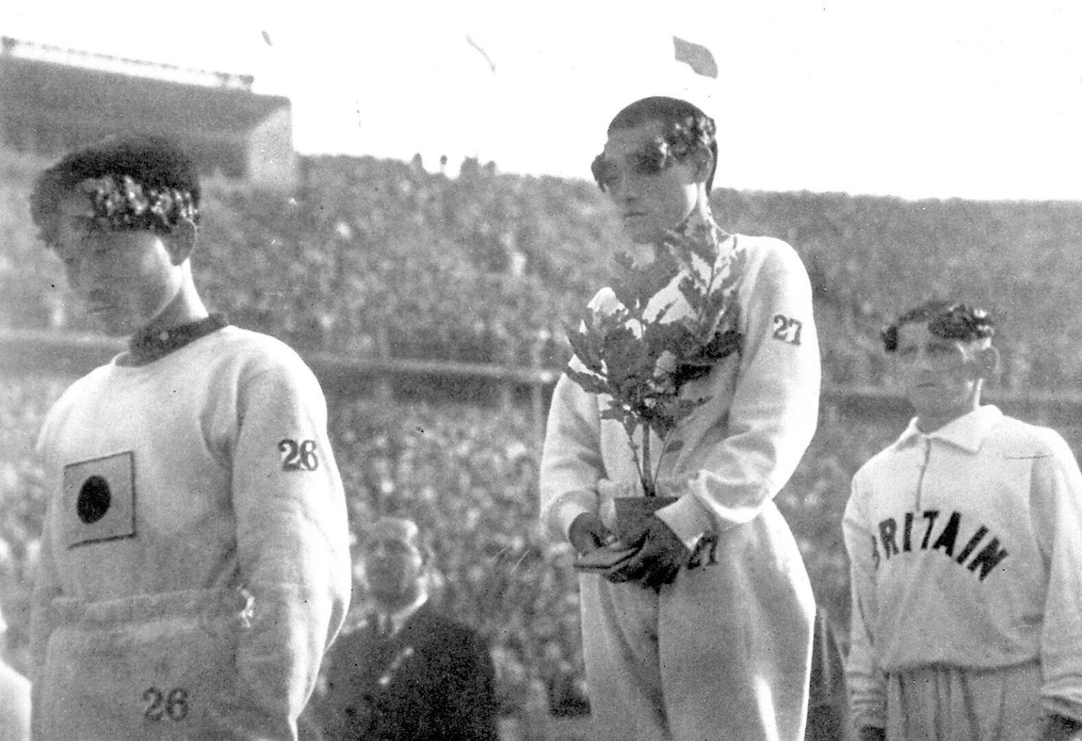 Sohn Kee-chung stands atop the podium with his head lowered after winning gold in the marathon at the 1936 Berlin Olympic Games. Photo: Kyodo via Reuters
