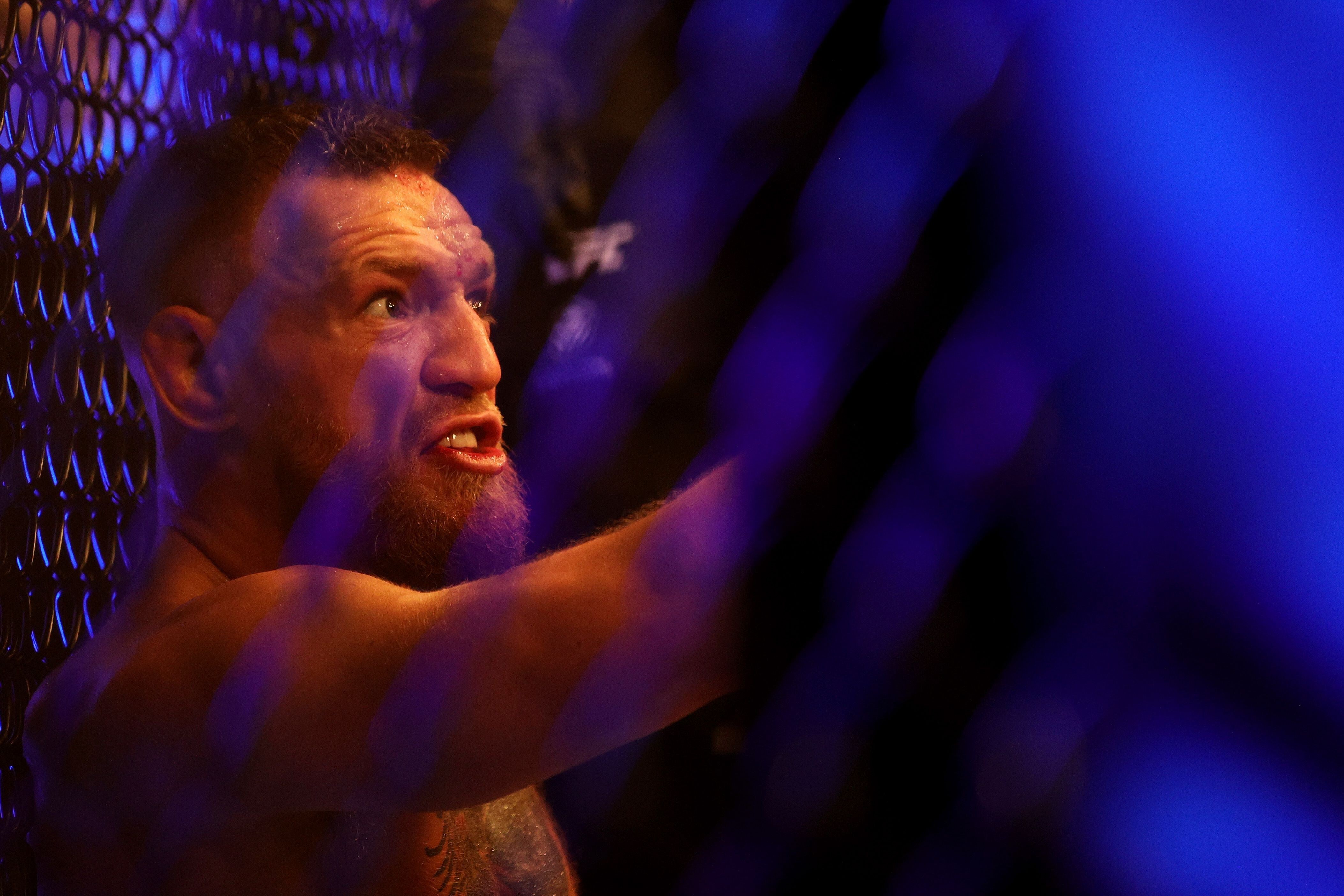 Conor McGregor sits on the mat after injuring his ankle in the first round of his lightweight bout against Dustin Poirier at UFC 264. Photo: AFP