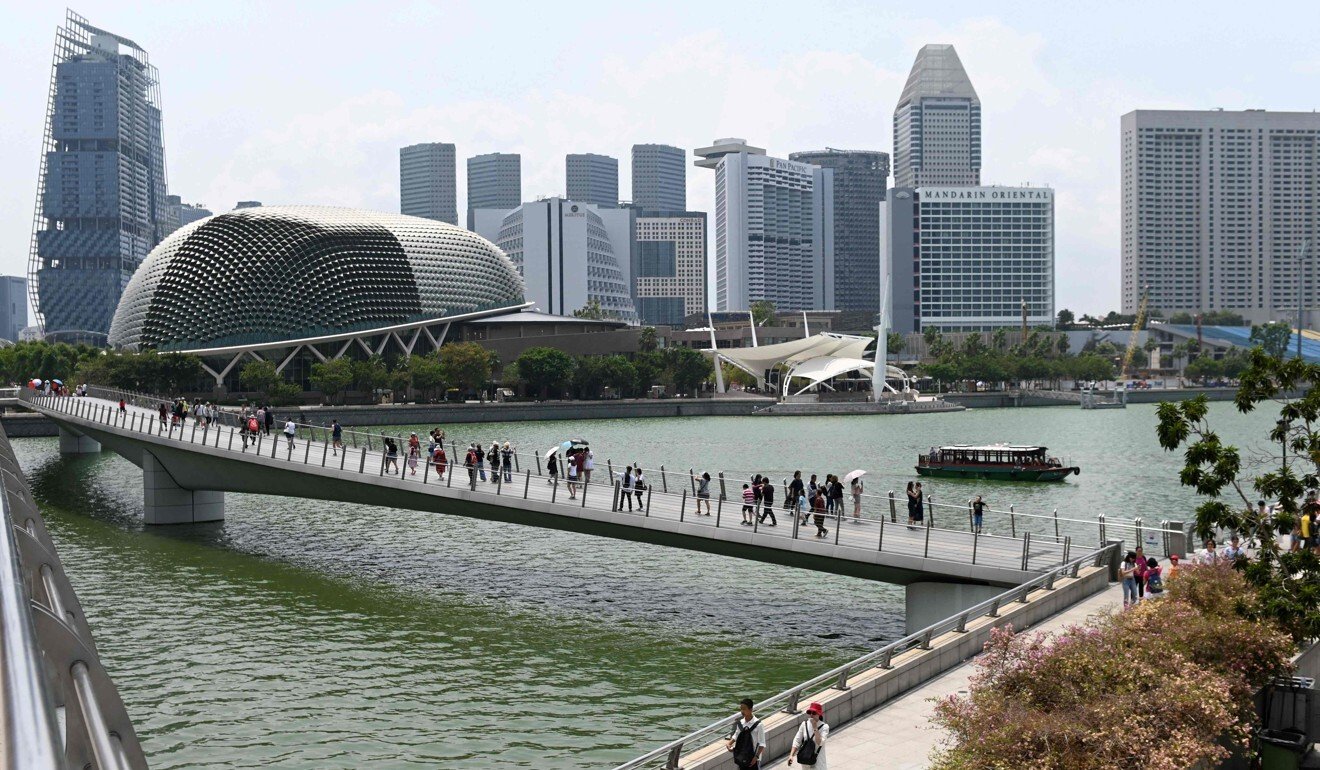 Visitors walk along the bridge leading to the Merlion park in Singapore. Photo: AFP