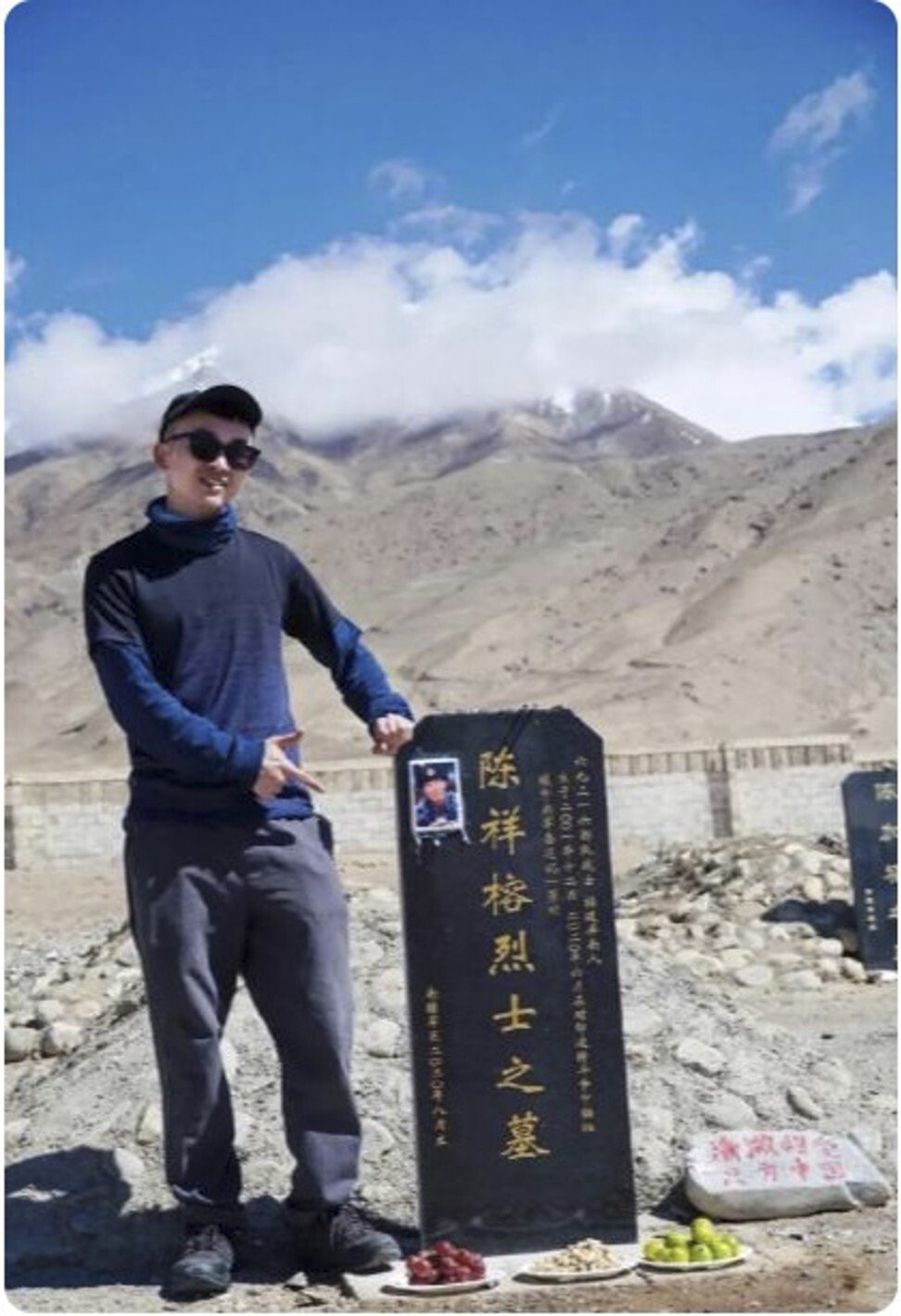 Blogger Xiao Xian holds his hand in the shape of what many believed looks like a gun pointing at a soldier’s grave. Photo: Xiao Xian Jayson