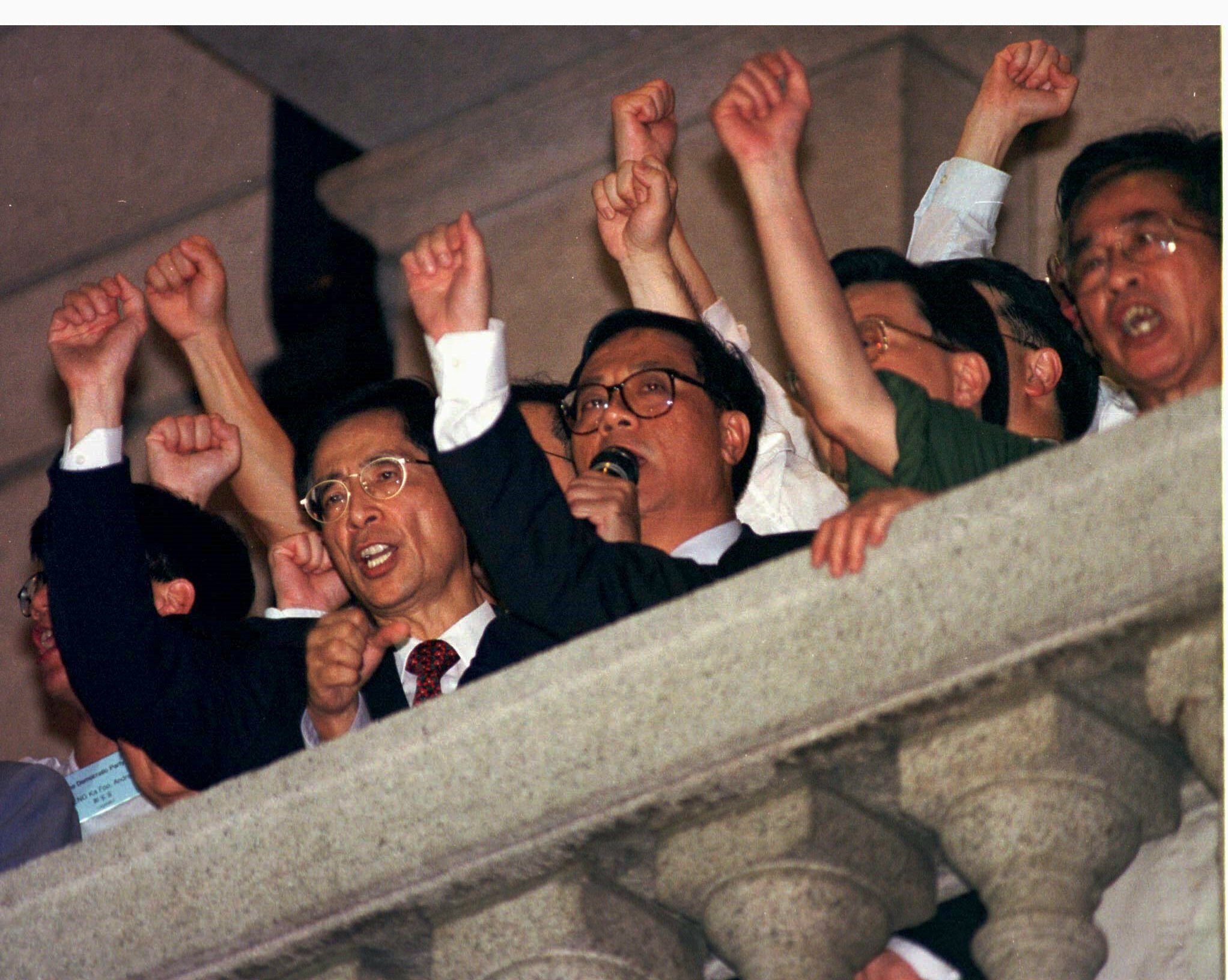 Martin Lee (left) and other Hong Kong pan-democrats address a crowd from the balcony of the former Legco building on the night before the handover. Photo: Reuters